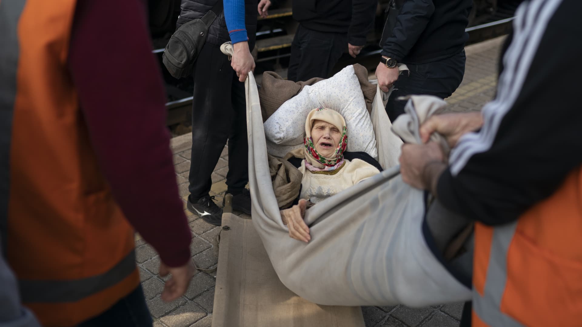 Klavidia, 91, is carried on an improvised stretcher as she boards a train, fleeing the war in Severodonetsk at a train station in Pokrovsk, Ukraine, Monday, April 25, 2022.