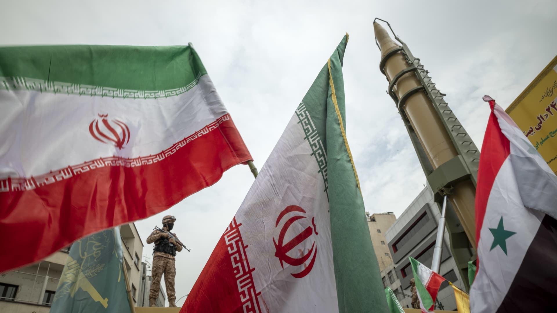 An Islamic Revolutionary Guard Corps (IRGC) military personnel stands guard next to two Iranian Kheibar Shekan Ballistic missiles in downtown Tehran as demonstrators wave Irans and Syrian flags during a rally commemorating the International Quds Day, also known as the Jerusalem day, on April 29, 2022.