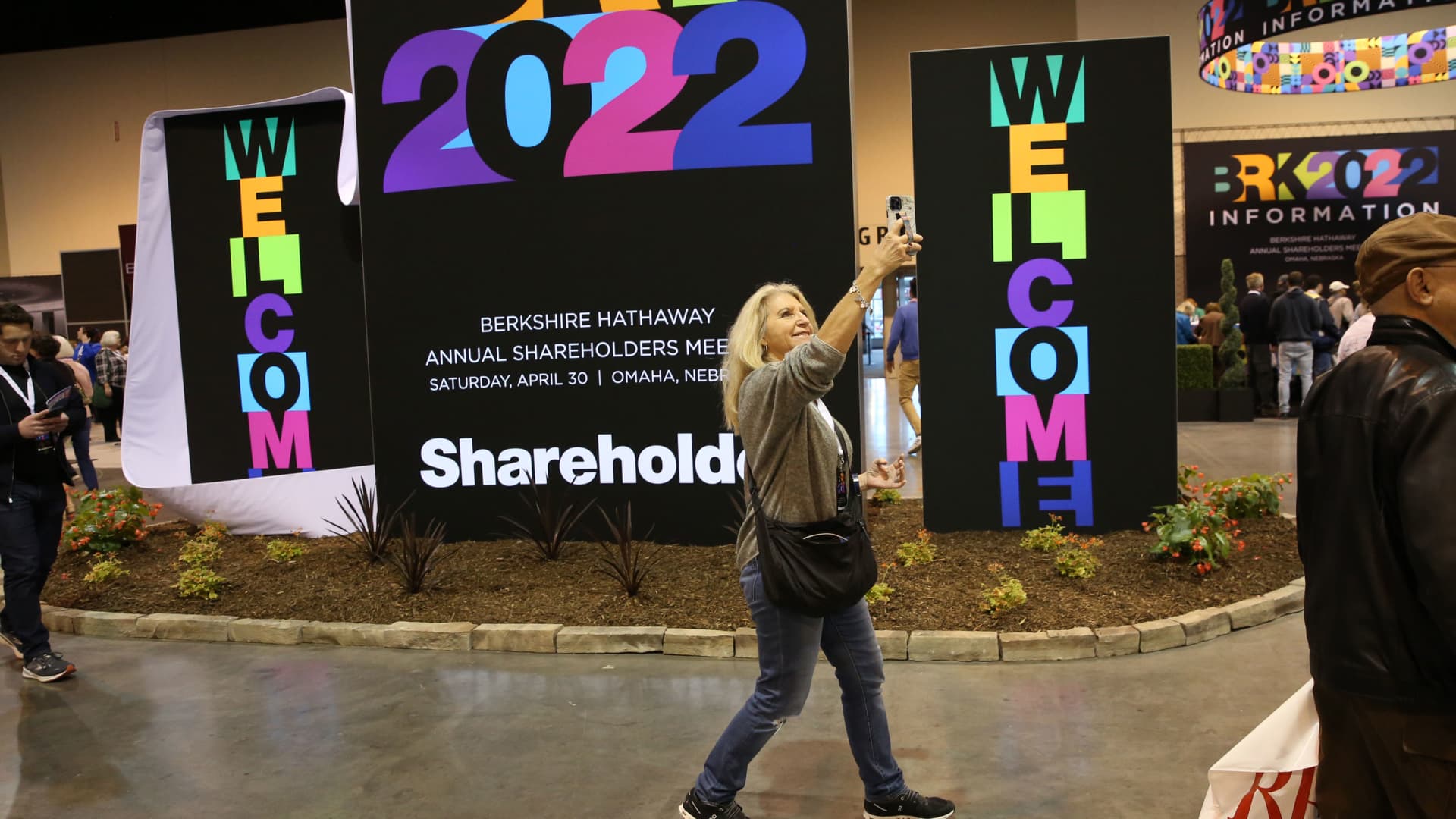 A woman takes a selfie in front of Berkshire Hathaway signage at the Berkshire Hathaway Annual Shareholders Meeting in Omaha, Nebraska.