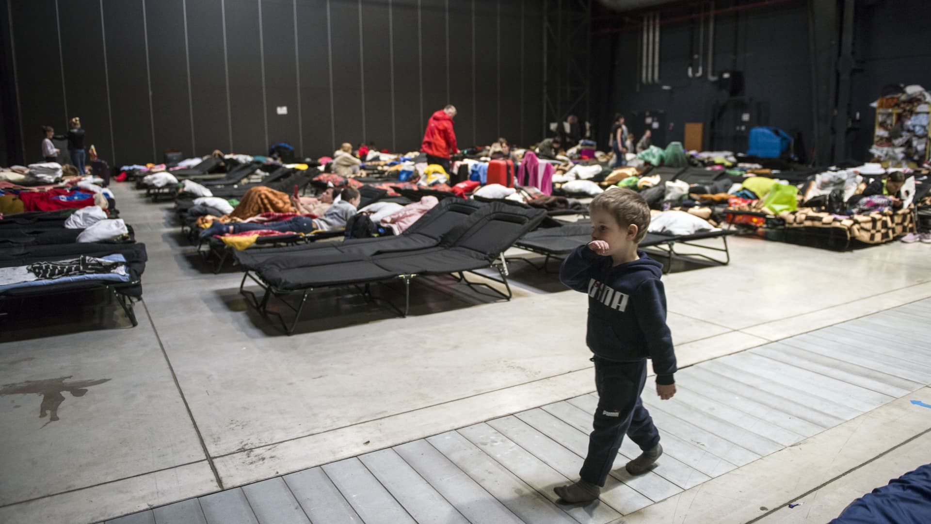 A Ukrainian boy walks past temporary beds at a refugee center in Warsaw on April 19.