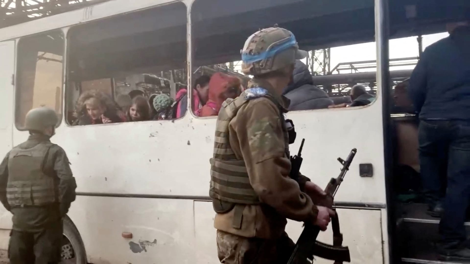 Azov regiment members stand as civilians board a bus at the Azovstal steel plant during UN-led evacuations, after nearly two months of siege warfare on the city by Russia during its invasion, in Mariupol, Ukraine in this still image from handout video released May 1, 2022. David Arakhamia/Azov Regiment/Handout via REUTERS THIS IMAGE WAS PROVIDED BY A THIRD PARTY. MANDATORY CREDIT. NO RESALES. NO ARCHIVES.