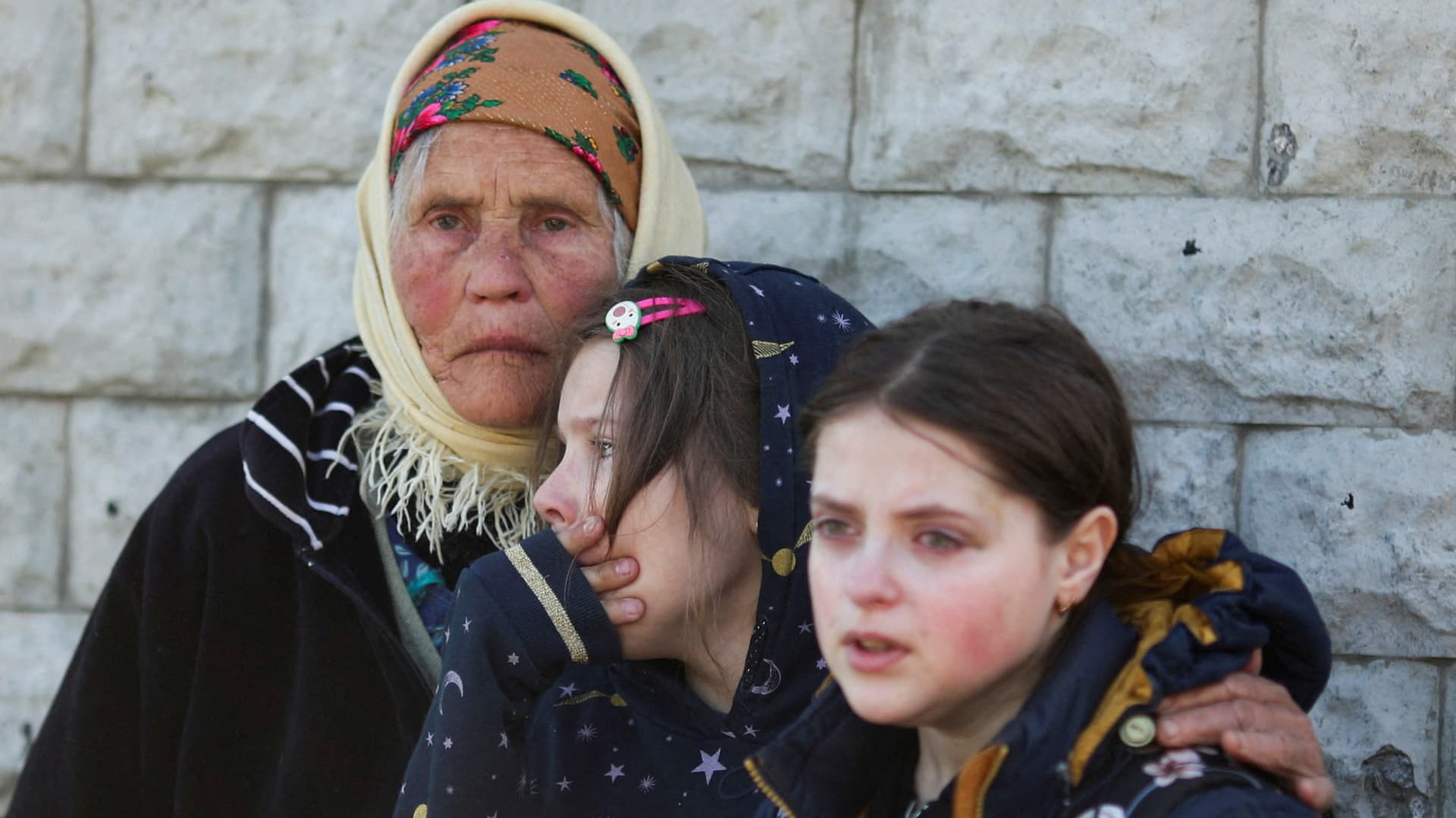 Residents react as they are evacuated from a village retaken by Ukrainian forces, next to a frontline, amid Russia's invasion of Ukraine, near Kharkiv, Ukraine, May 2, 2022. 