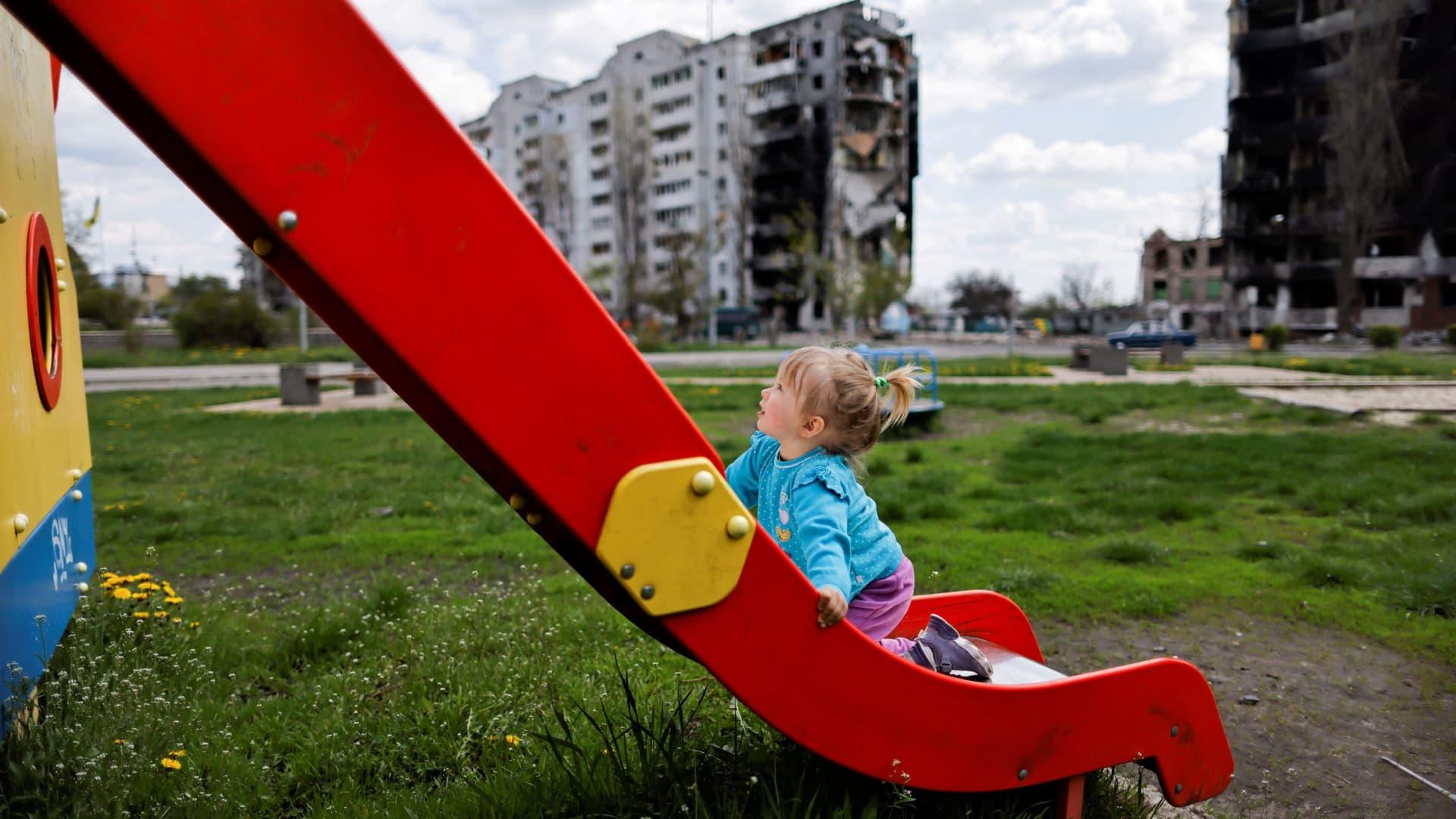 Nina Stefuryak, 2, plays at the playground in front of a building, destroyed by shelling, amid the Russian invasion of Ukraine, in Borodianka, Kyiv region, Ukraine, May 2, 2022. 