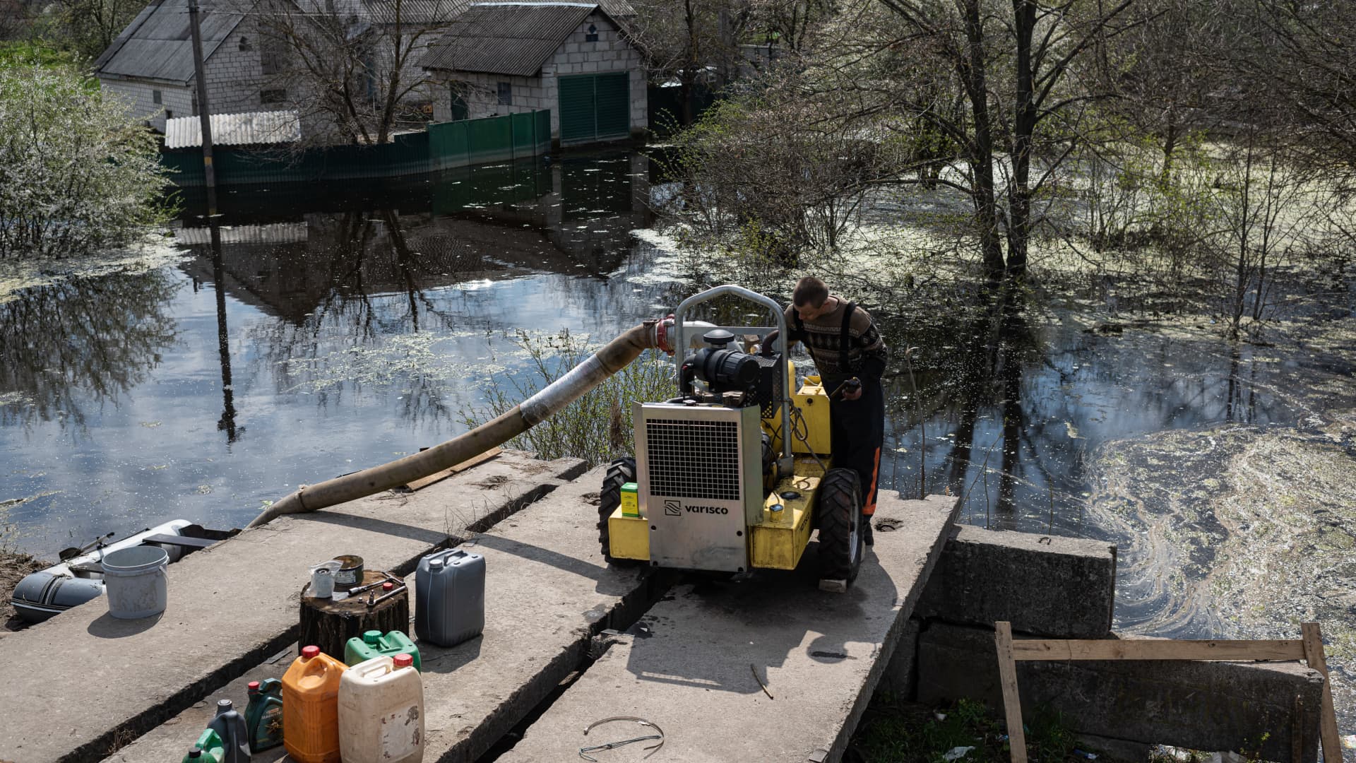 Oleksandr, 39, fixes the pumps he uses to pump out the water from the flooded areas, on May 2, 2022 in Demydiv, Ukraine. T