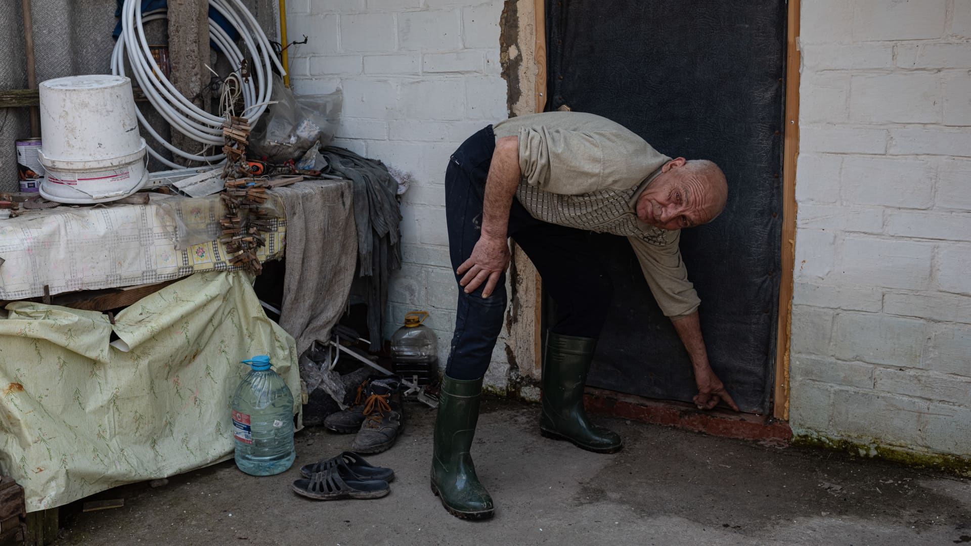 Serhii, 63, shows the initial flooding level in his household, on May 2, 2022 in Demydiv, Ukraine.