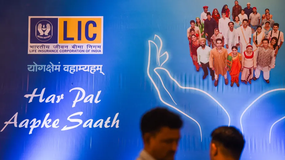 The LIC logo looms above a couple of passersby in Mumbai in India last week. The IPO of the biggest payer in life insurance in the country is expected to fetch $2.7 billion in the biggest IPO to-date.
