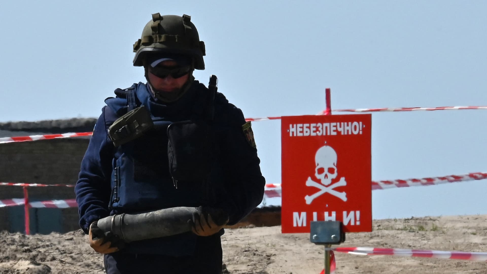 A Ukrainian deminer carries unexploded material during demining works at an airport in the town of Hostomel, northwestern of Kyiv, on May 5, 2022. 