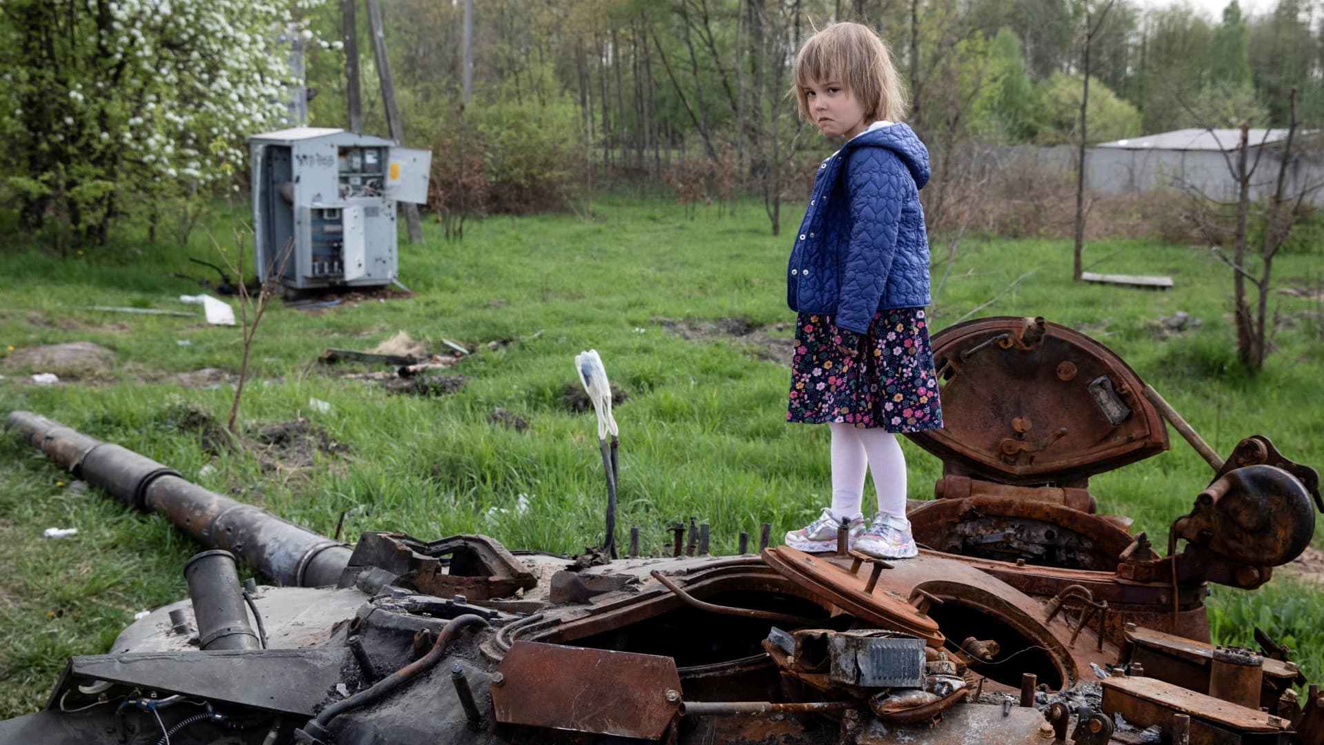 A child stands on a destroyed Russian tank, amid Russia's invasion of Ukraine, near Makariv, Kyiv region, Ukraine May 7, 2022.