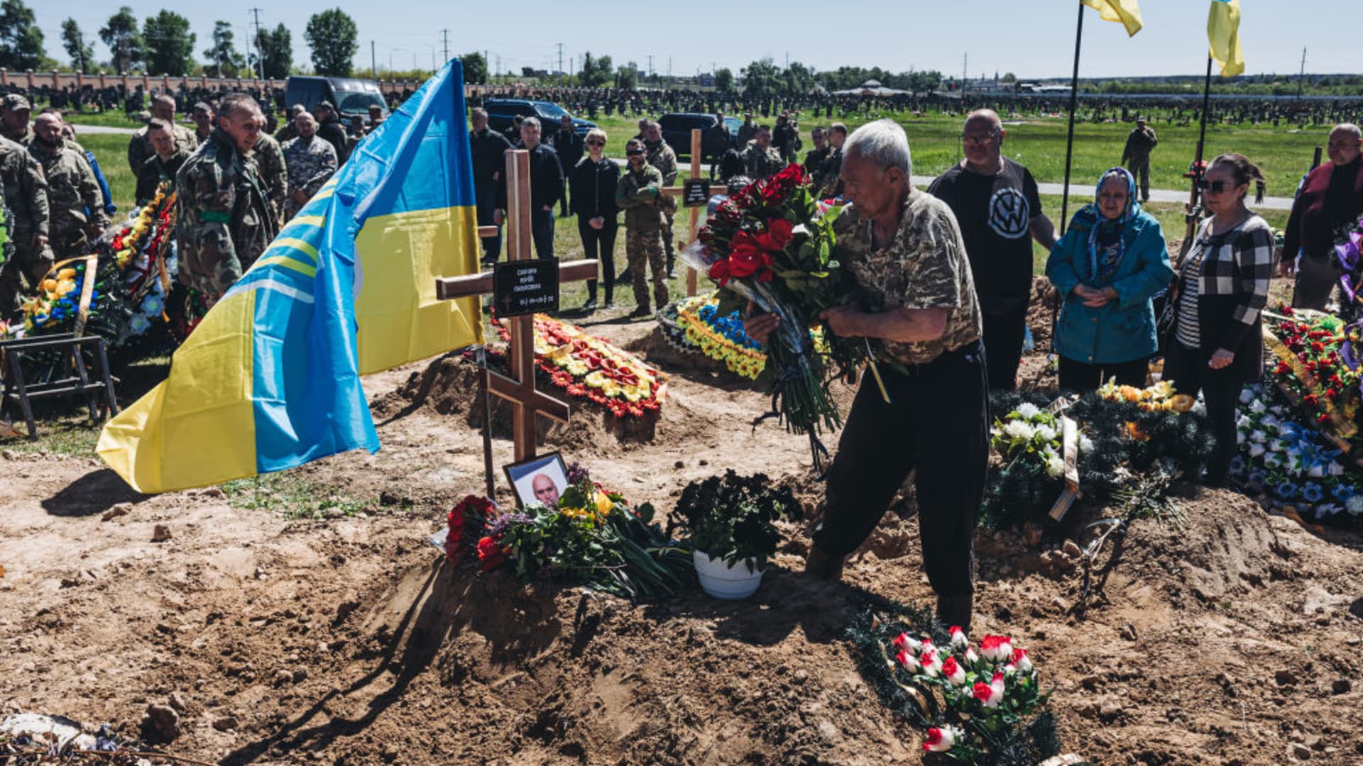 People attend the funeral of the fallen Ukrainian soldier in a cemetery of Kharkiv, Ukraine on May 7, 2022.