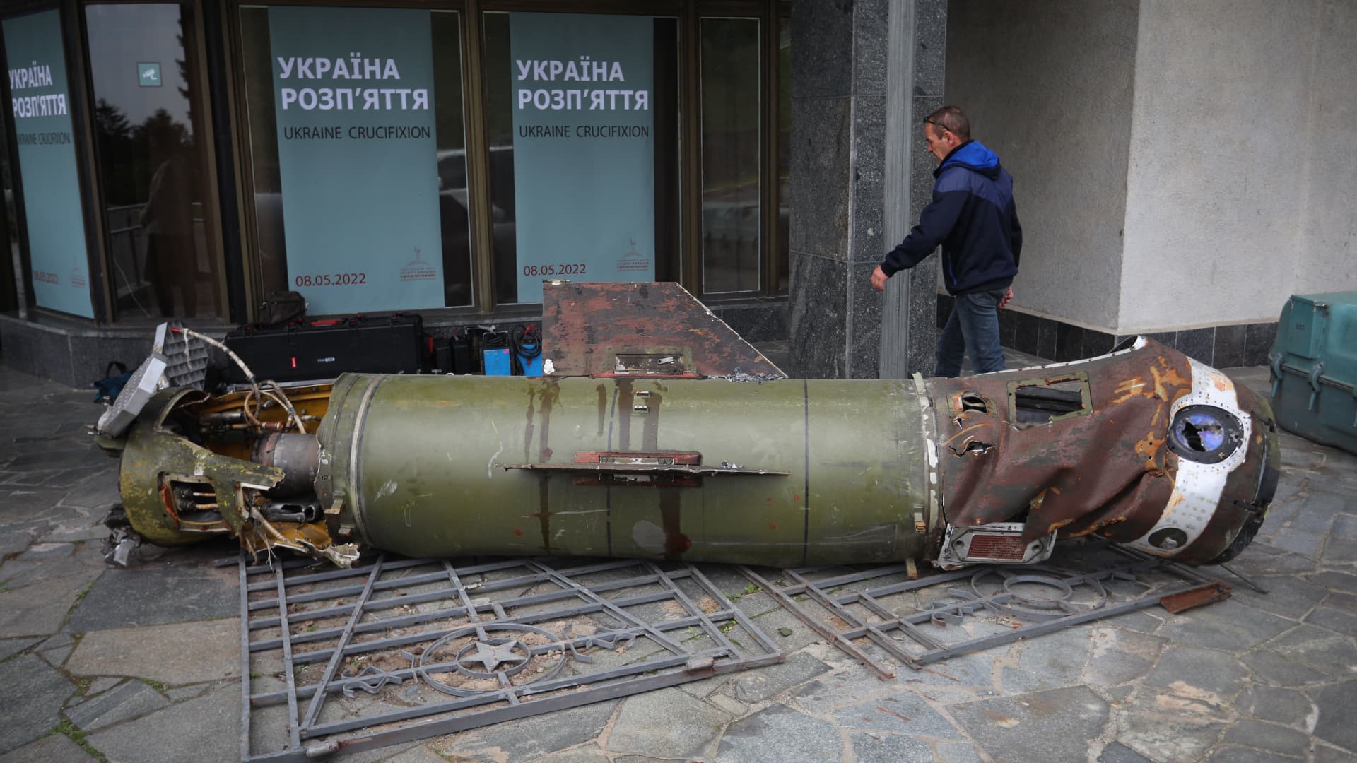 A visitor walks past the remains of a missile from the recent Ukraine Russia conflict, at the entrance to the World War II open-air museum in Kyiv on May 8, 2022, a day before 'Victory Day' is commemorated in Ukraine.
