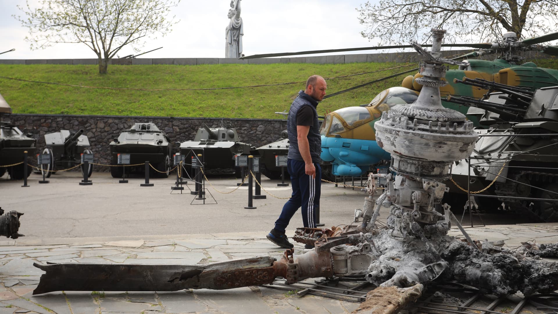 A man walks past a destroyed Russian helicopter from the recent Ukraine Russia conflict, at the World War II open-air museum in Kyiv on May 8, 2022, a day before 'Victory Day' is commemorated in Ukraine.