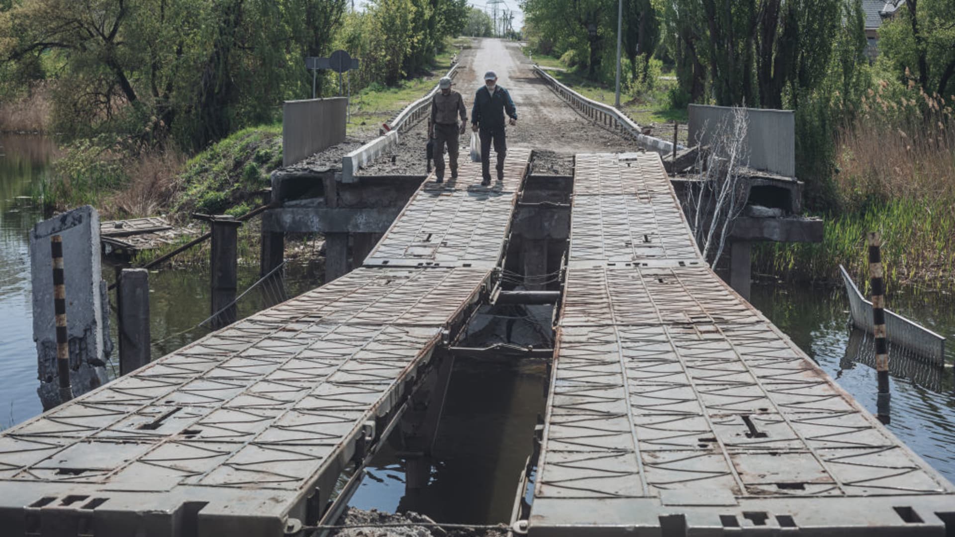 KHARKIV, UKRAINE - MAY 8: Two men cross a destroyed bridge on the outskirts of Kharkiv, Ukraine, 8 May 2022. (Photo by Diego Herrera Carcedo/Anadolu Agency via Getty Images)