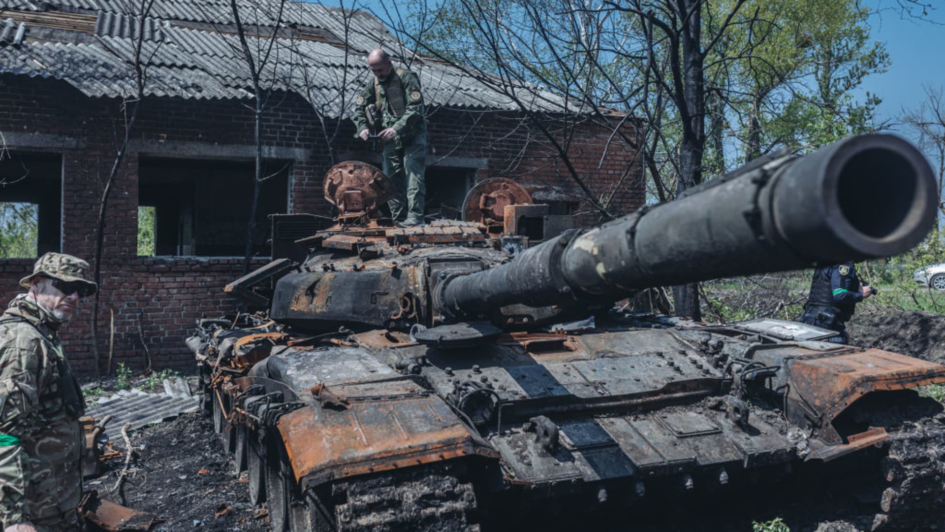 Ukrainian soldiers next to a destroyed Russian tank on the outskirts of Kharkiv, Ukraine, 8 May 2022.