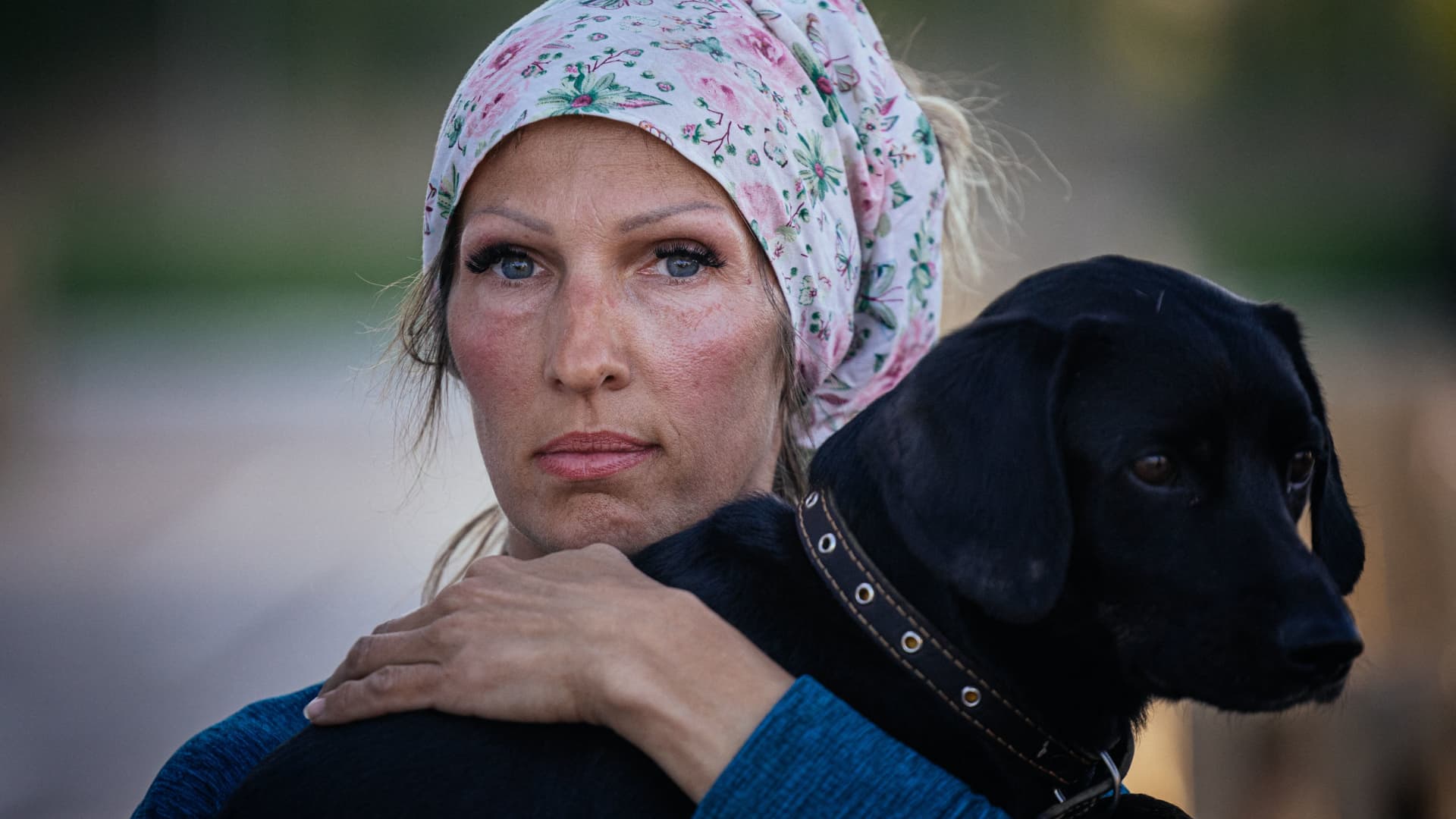 A woman holds her dog after arriving from Russian-occupied territory at a registration and processing area for internally displaced people in Zaporizhzhia, in Ukraine, on May 8, 2022.