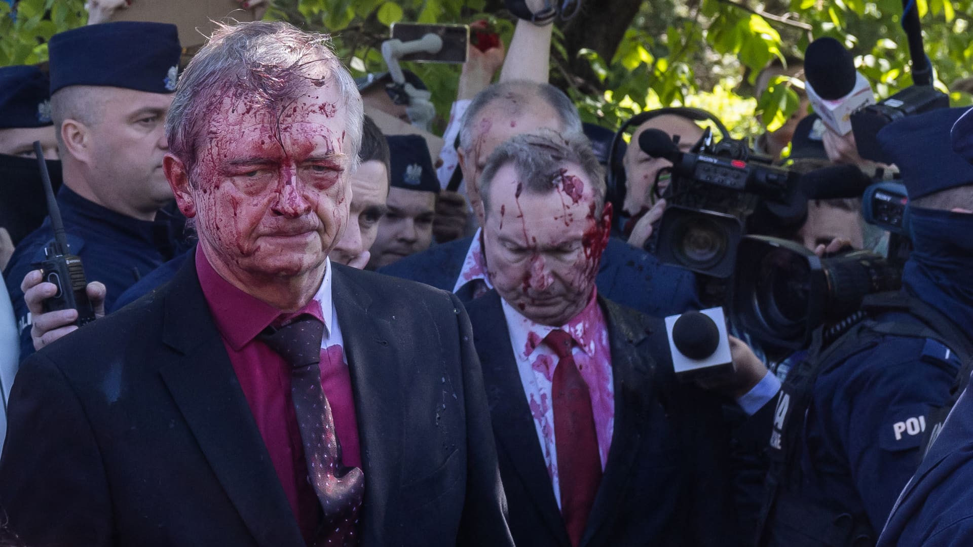 Russian Ambassador to Poland Sergey Andreev (L) gets in his car after being covered with red paint during a laying wreath ceremony at the Soviet soldier war mausoleum in Warsaw, Poland on May 9, 2022, on the day of the 77th anniversary of the 1945 Soviet victory against Nazi Germany.