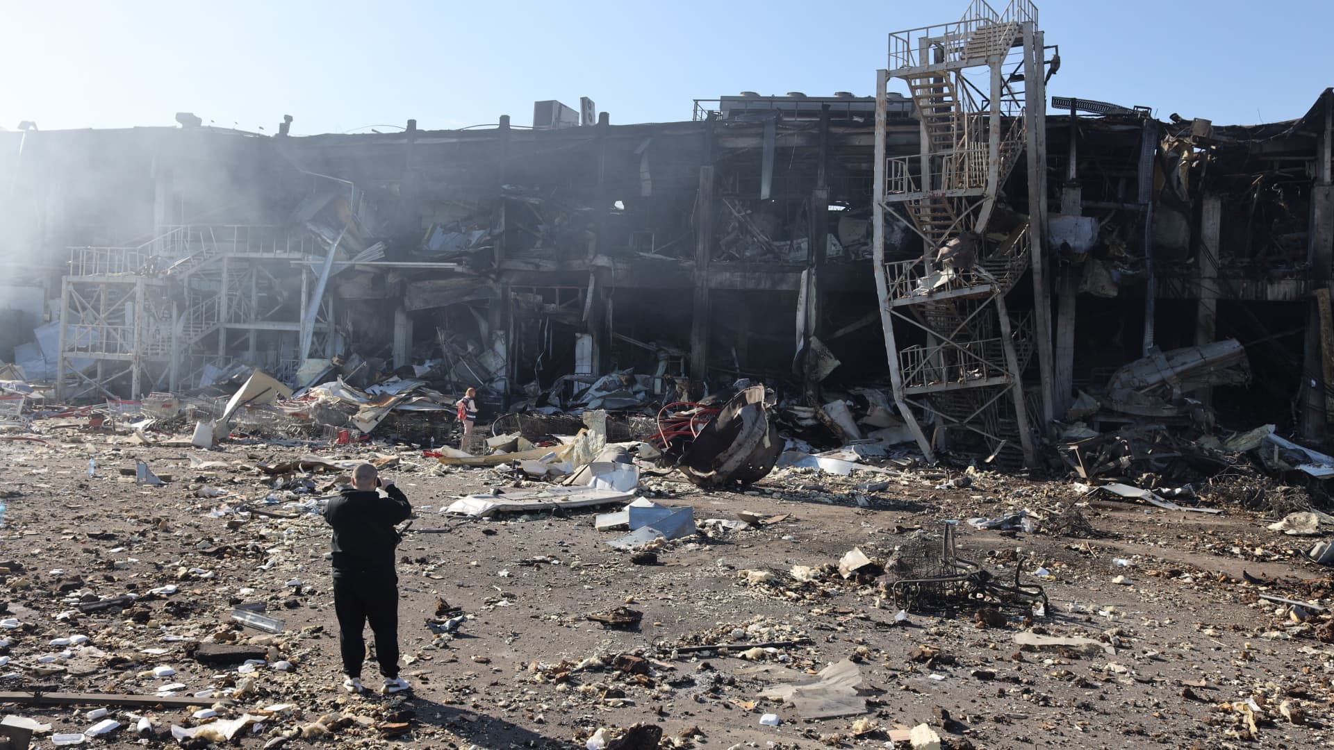 A man takes pictures of the shopping and entertainment center in the Ukrainian Black Sea city of Odessa on May 10, 2022, destroyed after Russian missiles strike late on May 9, 2022.