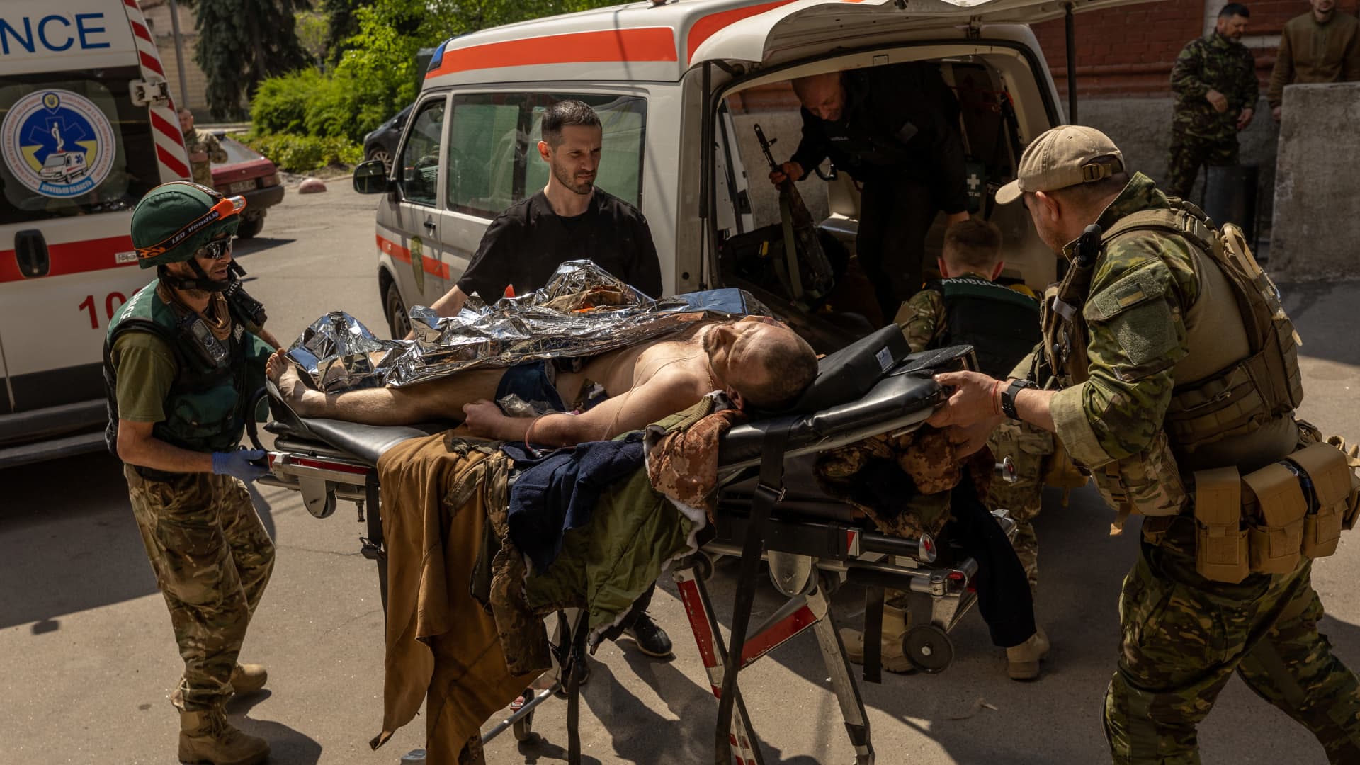 Paramedics from the Pirogov First Volunteer Mobile Hospital move an injured Ukrainian solider, who was evacuated from the front line in Popasna, from an ambulance, amid Russia's invasion in Ukraine, outside a hospital in Bakhmut, Donetsk region, Ukraine, May 5, 2022. 
