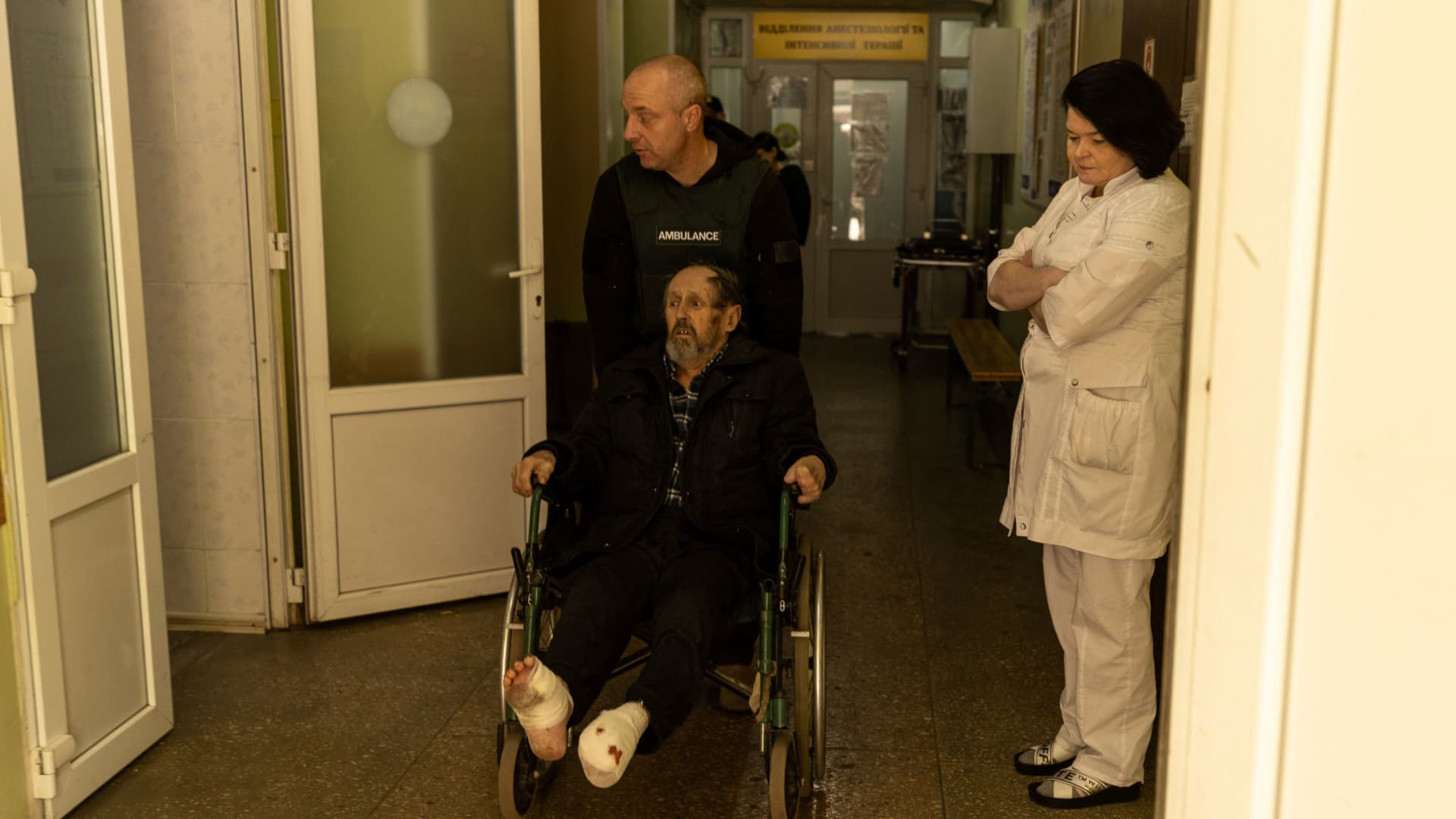 An elderly civilian man whose feet had to be amputated is helped in a wheelchair by a paramedic, amid Russia's invasion in Ukraine, in a hospital in Bakhmut, Donetsk region, Ukraine, May 6, 2022. 