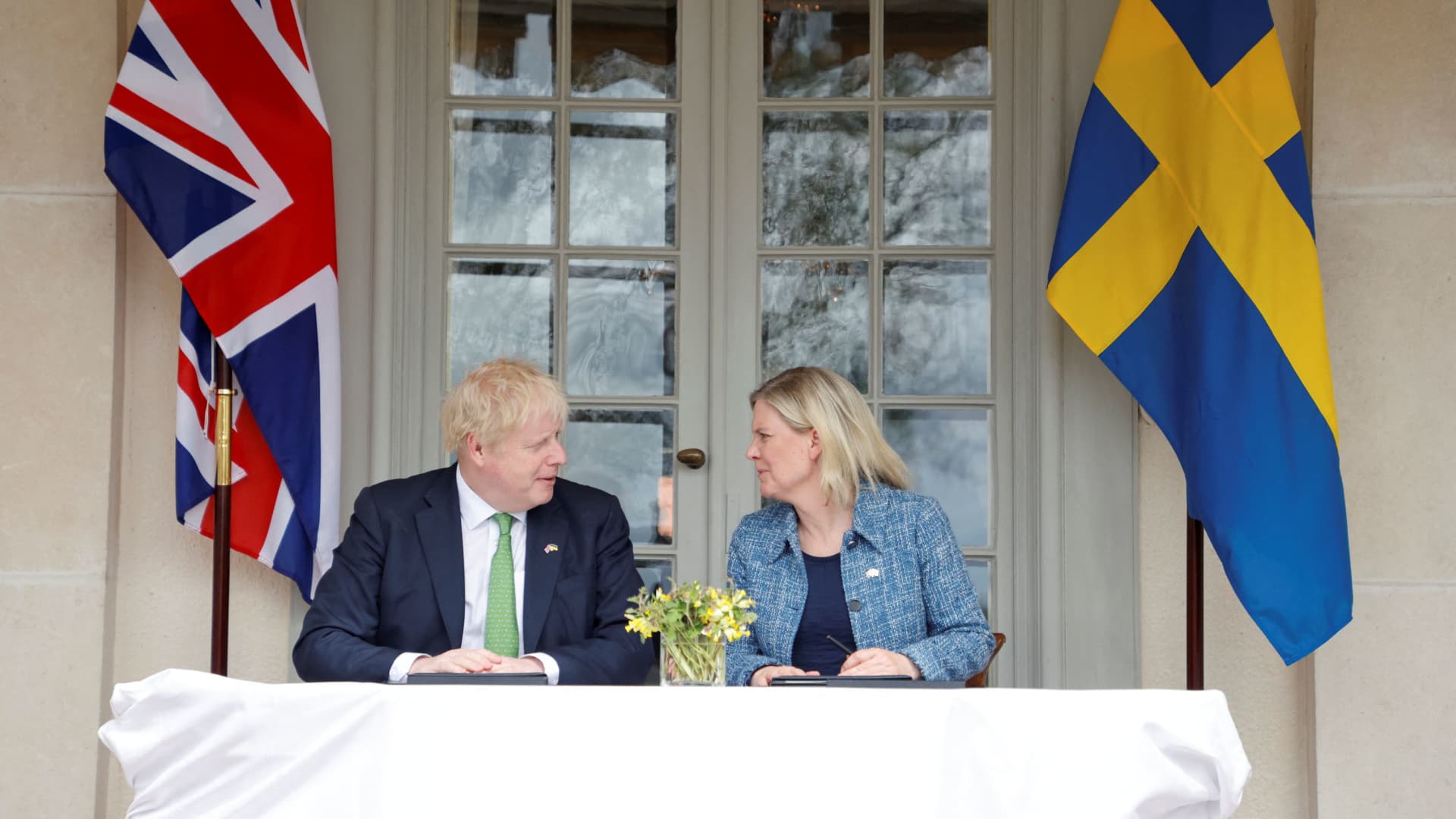 British Prime Minister Boris Johnson and Sweden's Prime Minister Magdalena Andersson sign documents as they meet at the Swedish Prime Minister's summer residence in Harpsund, Sweden May 11, 2022. 