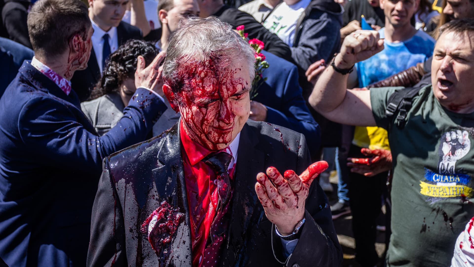 Russian Ambassador to Poland, Ambassador Sergey Andreev reacts after being covered with red paint during a protest prior a ceremony at the Soviet soldier war mausoleum in Warsaw, Poland on May 9, 2022, on the day of the 77th anniversary of the 1945 Soviet victory against Nazi Germany.