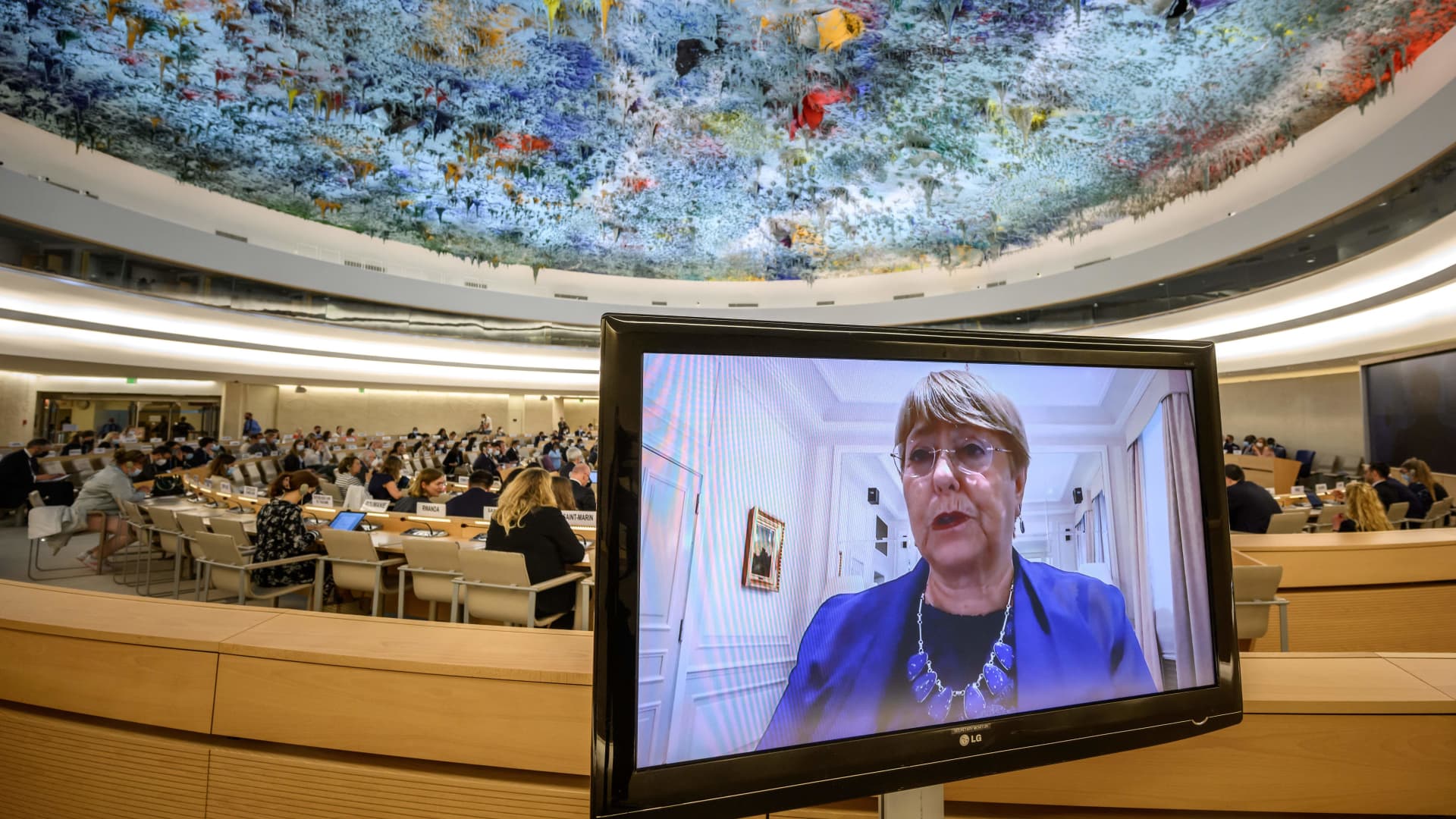 United Nations High Commissioner for Human Rights Michelle Bachelet is seen on a monitor delivering a remote speech during a special session of the UN Human Rights Council on Ukraine, in Geneva on May 12, 2022.