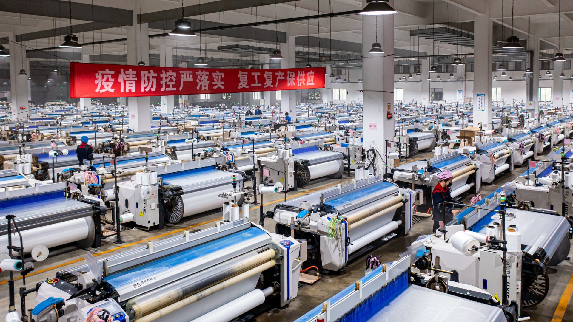 The latest Covid lockdowns in China have slowed the ability of trucks to transport goods throughout China, while keeping many factories in the Shanghai region at limited or no production for weeks. Pictured here is a textile company's workshop in the nearby Jiangsu province.