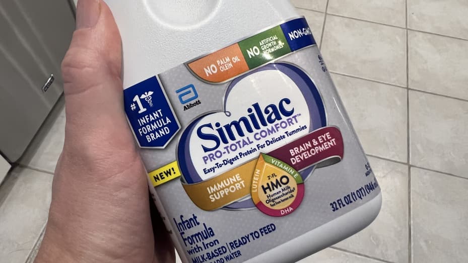 Person's hand holding a bottle of Similac baby formula from Abbott Laboratories in Lafayette, California, May 13, 2022.