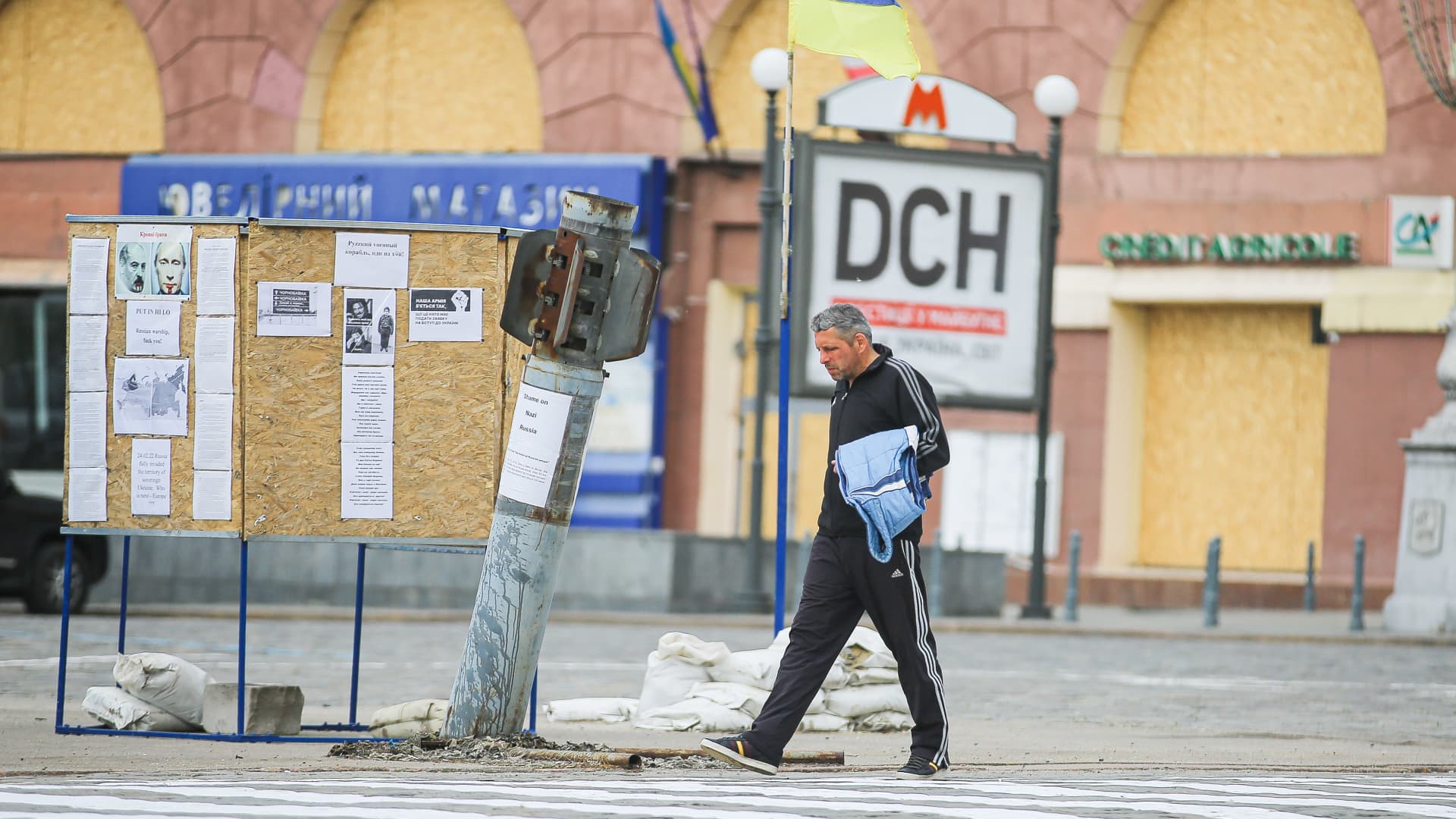 A man walks past the unexploded Grad rockets in front of the Kharkiv Regional Government headquarters in the center of Kharkiv.