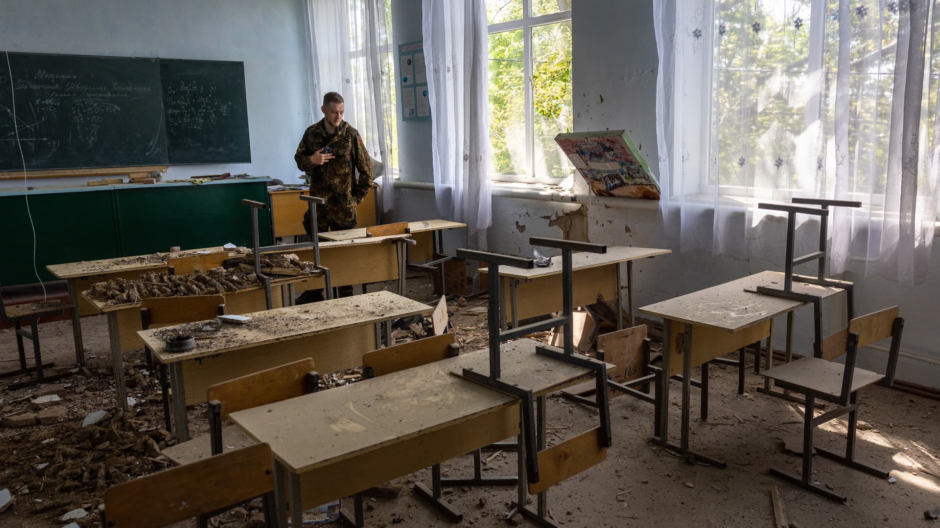 A soldier inspects a damaged classroom on May 8, 2022, in Kherson Oblast, Ukraine. Most of the region remains Russian occupied.
