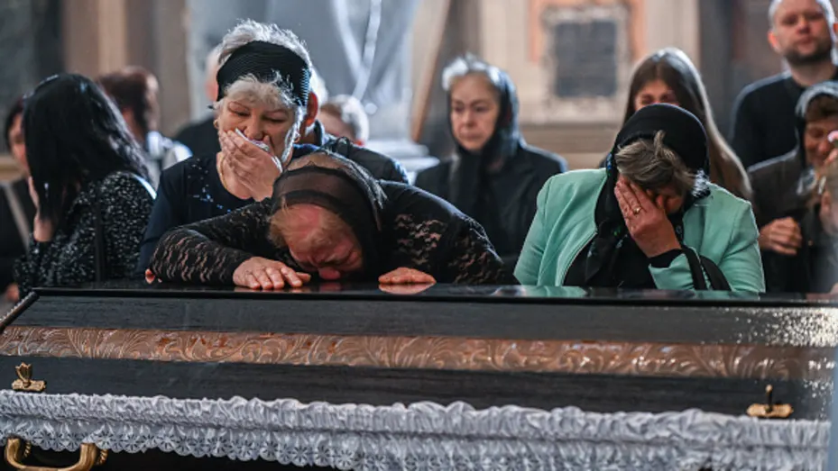 Los familiares lloran junto al ataúd del soldado caído ucraniano Yurii Huk, de 41 años, en la Iglesia de los Santos Apóstoles Pedro y Pablo en Lviv, Ucrania, el 16 de mayo de 2022.