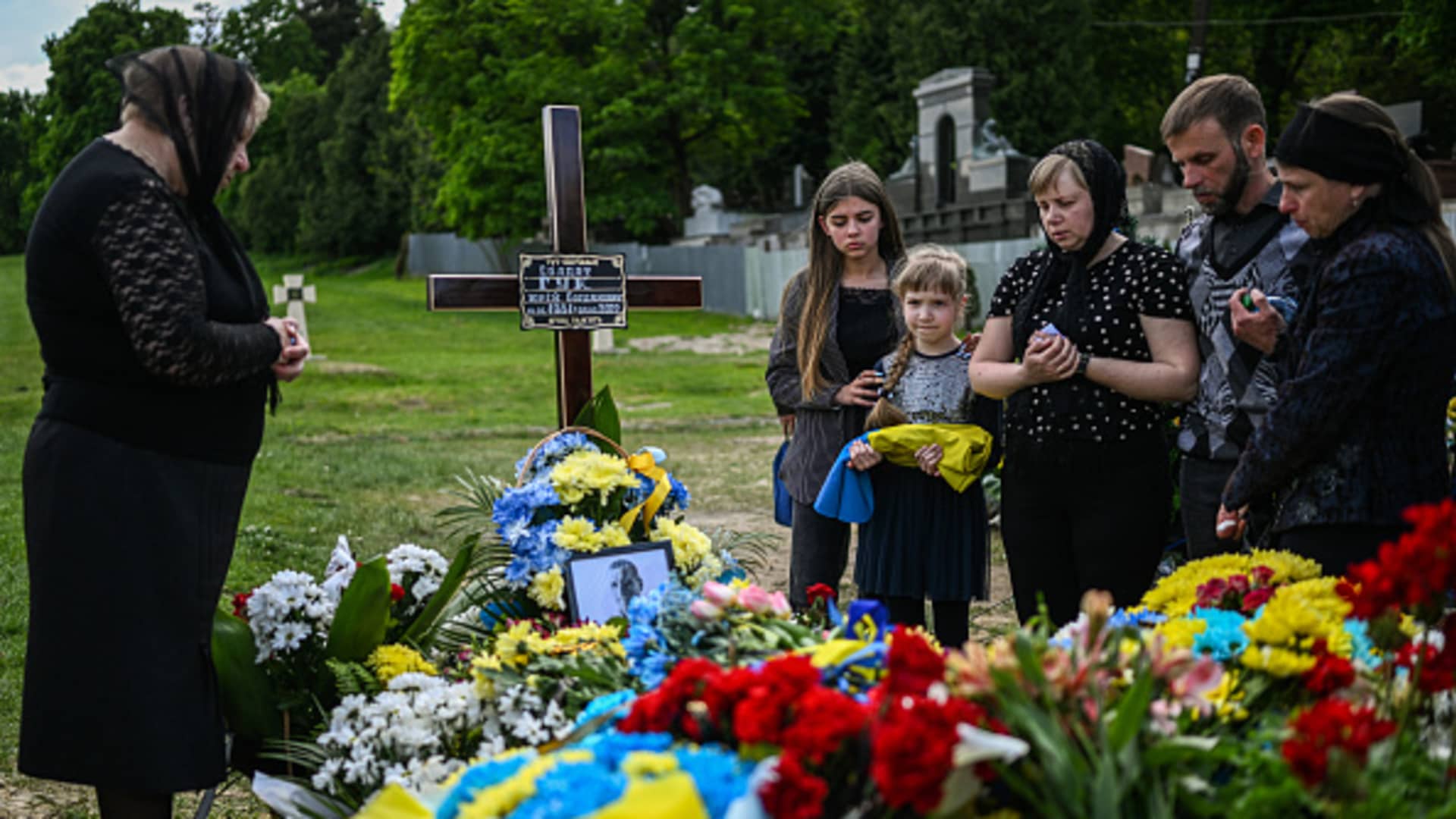 Relatives of the fallen soldier Yurii Huk, age 41 pay their respects by his grave at the Field of Mars of Lychakiv cemetery in Lviv, Ukraine on May 16, 2022.