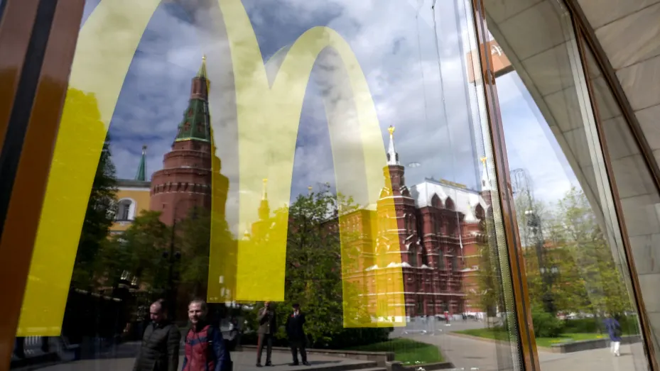 The Kremlin's towers and passers-by are seen reflected in the window of a closed McDonald's restaurant in Moscow on May 16, 2022. - American fast-food giant McDonald's will exit the Russian market and sell its business in the increasingly isolated country, the company said May 16, 2022. In a statement McDonald's said: "After more than 30 years of operations in the country, McDonald's Corporation announced it will exit the Russian market and has initiated a process to sell its Russian business. Many Western