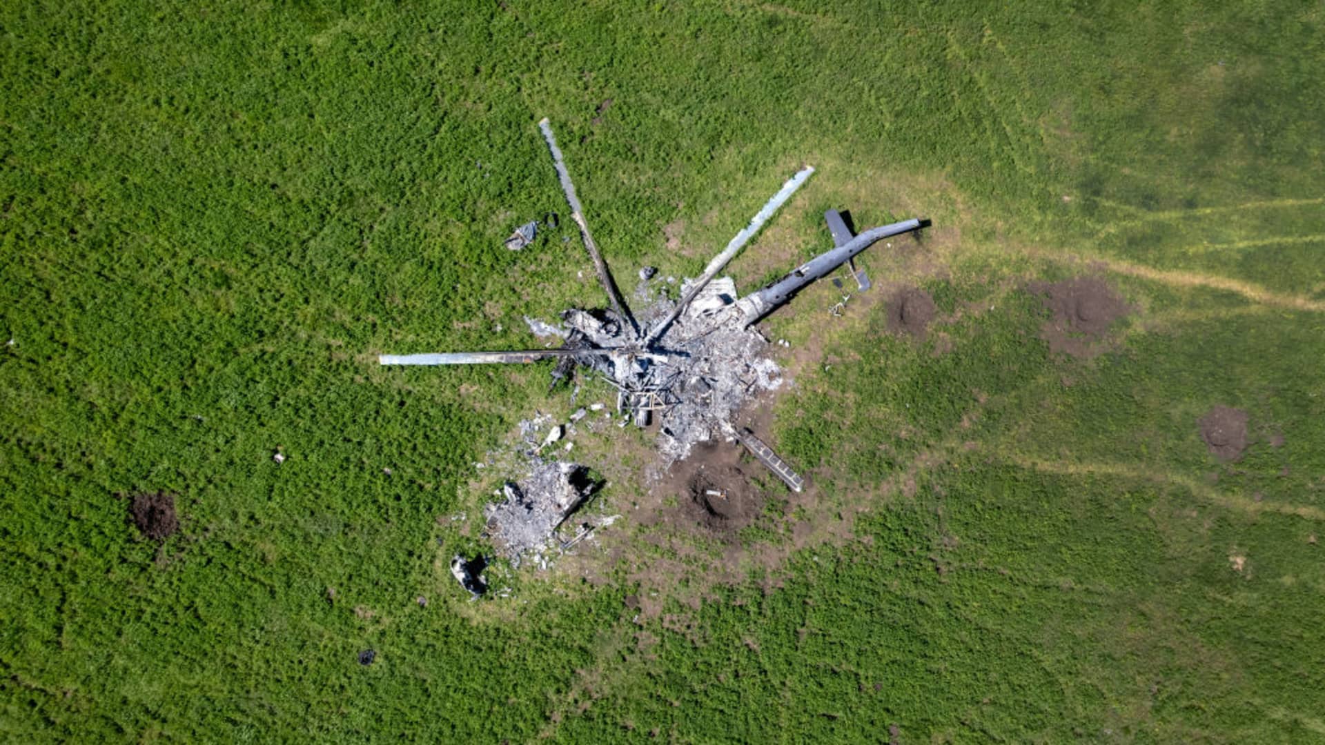 As seen from above, the remains of a Russian helicopter lies in a bomb-cratered field on May 16, 2022 in Biskvitne, Ukraine to the east of Kharkiv.
