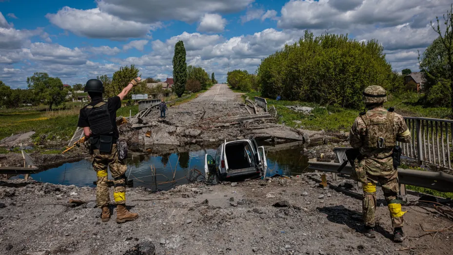 Soldados de la unidad de fuerzas especiales ucranianas Kraken hablan con un hombre en un puente destruido en la carretera cerca del pueblo de Rus'ka Lozova, al norte de Kharkiv, el 16 de mayo de 2022.