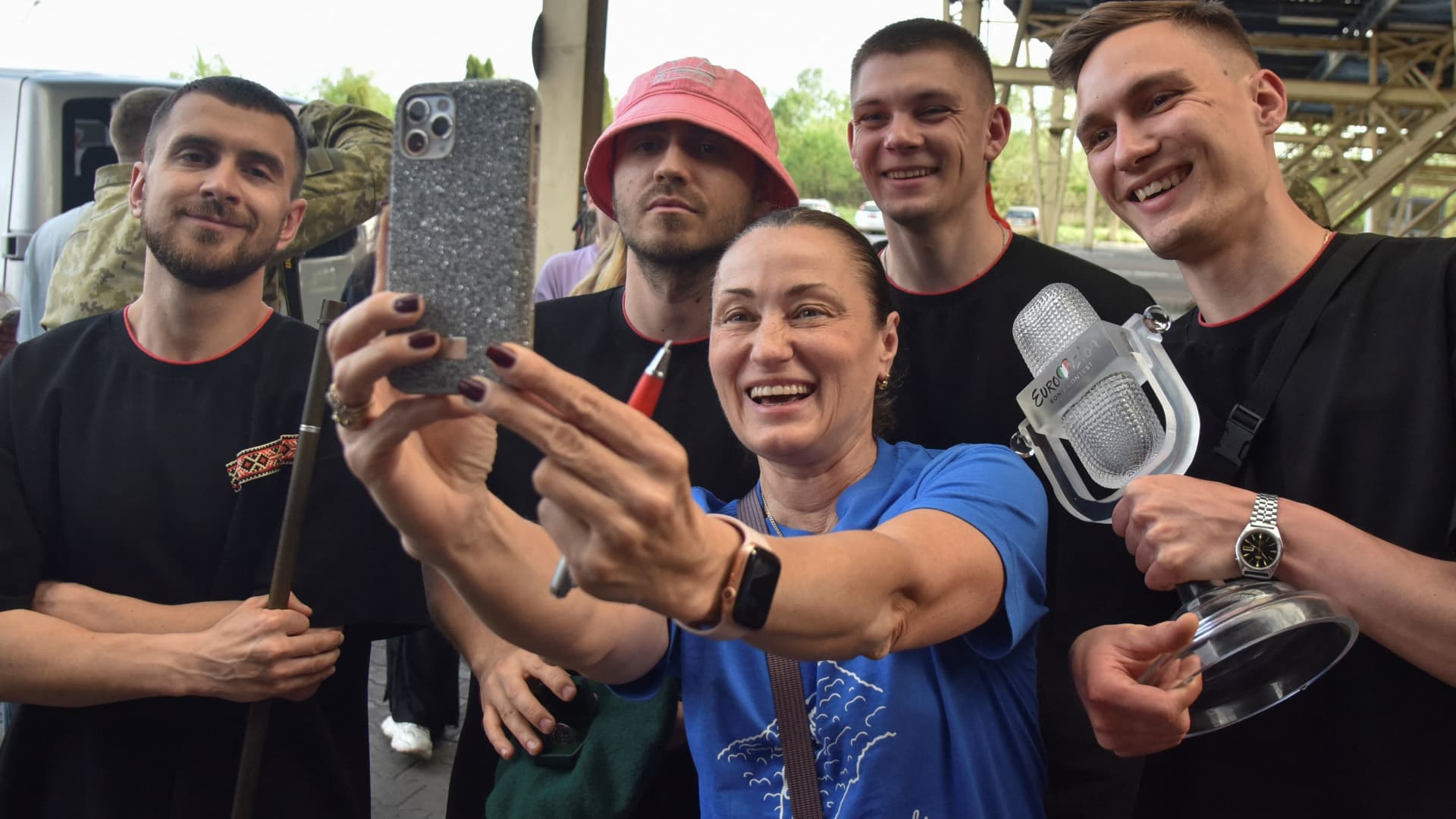 Kalush Orchestra, the winners of the 2022 Eurovision Song Contest, pose for a selfie picture with a Ukrainian woman as they arrive at the Ukraine-Poland border crossing point near the village of Krakovets, in Lviv region, Ukraine May 16, 2022. 