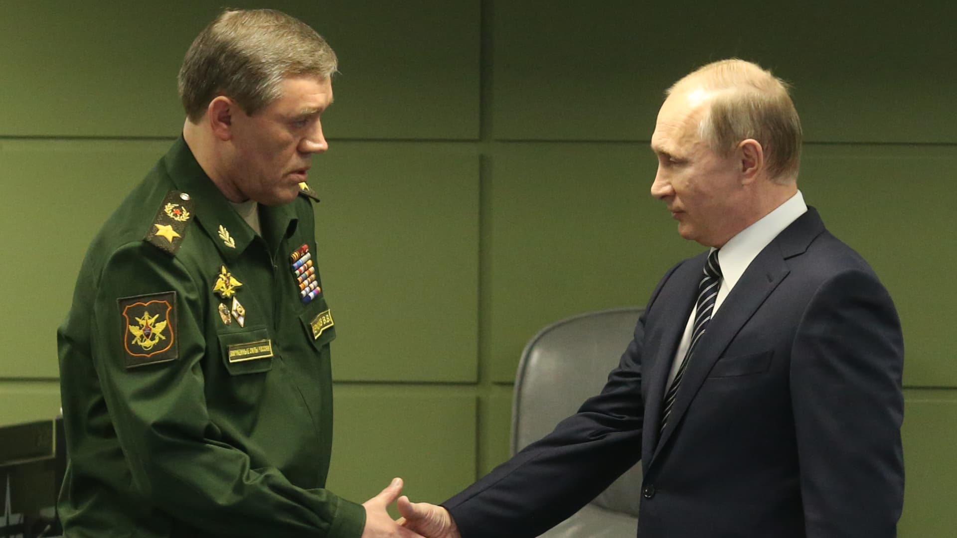 Russian President Vladimir Putin (R) greets Chief of General Staff of Armed Forces Valery Gerasimov (L) while vivting the National Defense Center in Moscow, Russia, March,11,2016.