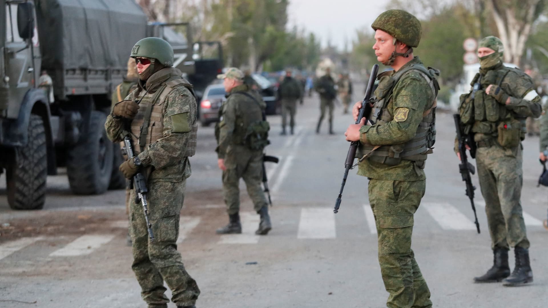 Service members of pro-Russian troops stand guard on a road before the expected evacuation of wounded Ukrainian soldiers from the besieged Azovstal steel mill in the course of Ukraine-Russia conflict in Mariupol, Ukraine May 16, 2022.