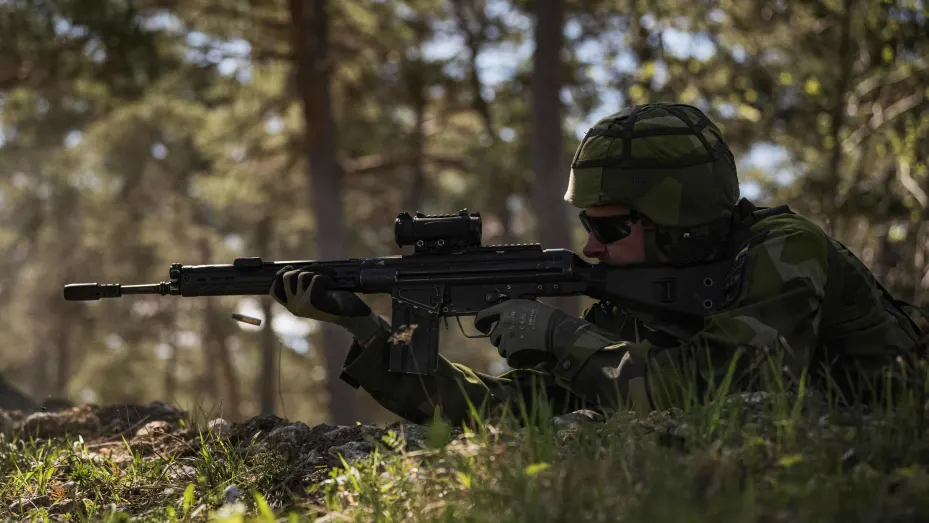 A Swedish Home Guard soldier fires a shot as he takes part in a field exercise near Visby on the Swedish island of Gotland on May 17, 2022. - Finland and Sweden are expected to announce this week whether to apply to join NATO following Russia's Ukraine invasion, in what would be a stunning reversal of decades-long non-alignment policies. On Sweden's strategically-located Baltic Sea island of Gotland, Home Guard troops were last week called in for a special month-long training exercise, coinciding with annua