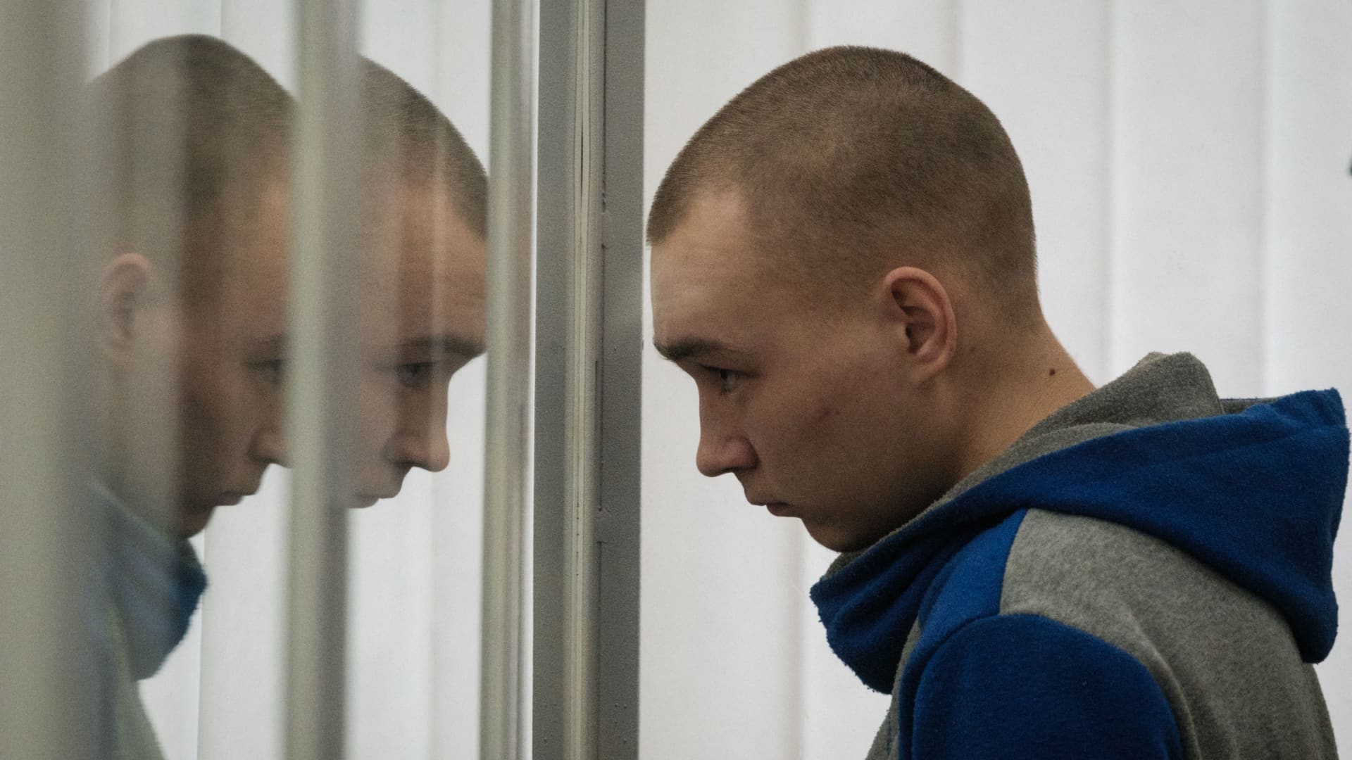 Russian Sergeant Vadim Shishimarin stands and listens translator's words in the defendant's box during his trial on charges of war crimes for having killed a civilian at the Court of Appeal in Kyiv, on May 20, 2022.