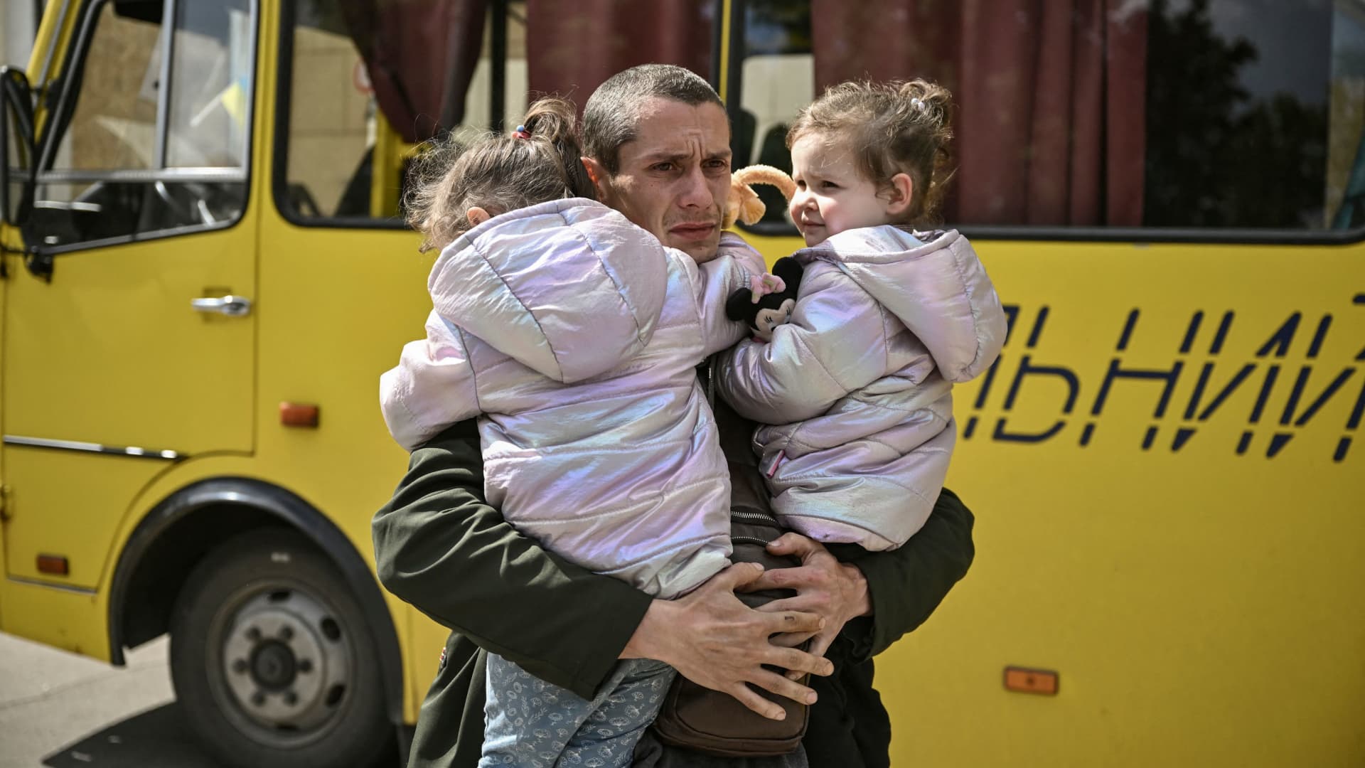 Dmytro Mosur, 32, who lost his wife during shelling in nearby Severodonetsk on May 17, holds his 2-year-old twin daughters as they wait to be evacuated from the city of Lysychansk, eastern Ukraine, on May 20, 2022.