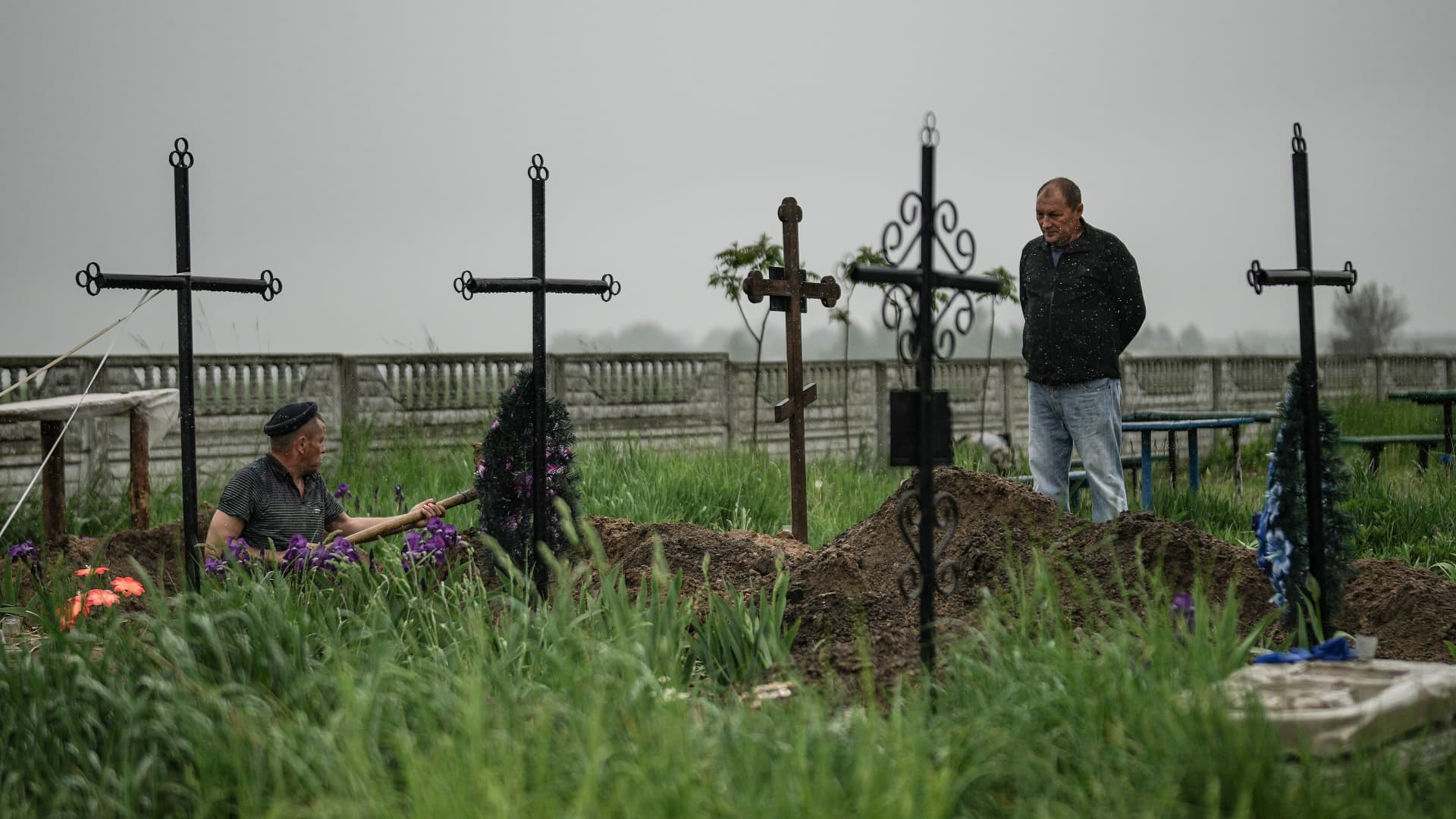 Buzova village resident Oleksandr (surname withheld) looks on as police exhume the bodies of his mother, brother and son to investigate alleged war crimes by Russian forces during the invasion of Ukraine on May 21, 2022 in Kyiv, Ukraine.