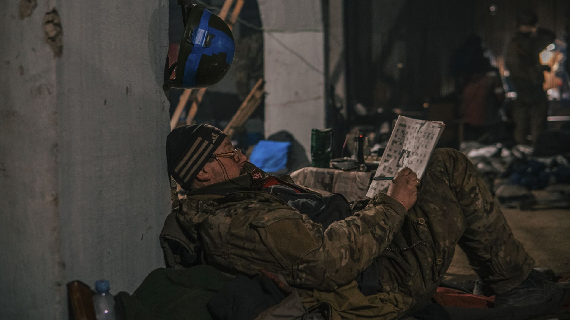 A Ukrainian soldier does crossword as he has a rest in his shelter in Mariupol, Ukraine, May 7, 2022. 