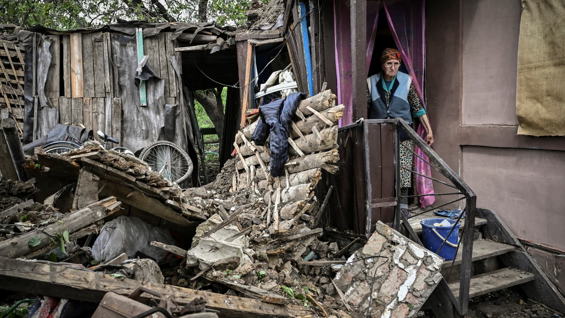 An eldery woman stands inside her heavily damaged house after it was hit by a missile in the city of Bakhmut at the eastern Ukranian region of Donbass on May 22, 2022, amid Russian invasion of Ukraine.