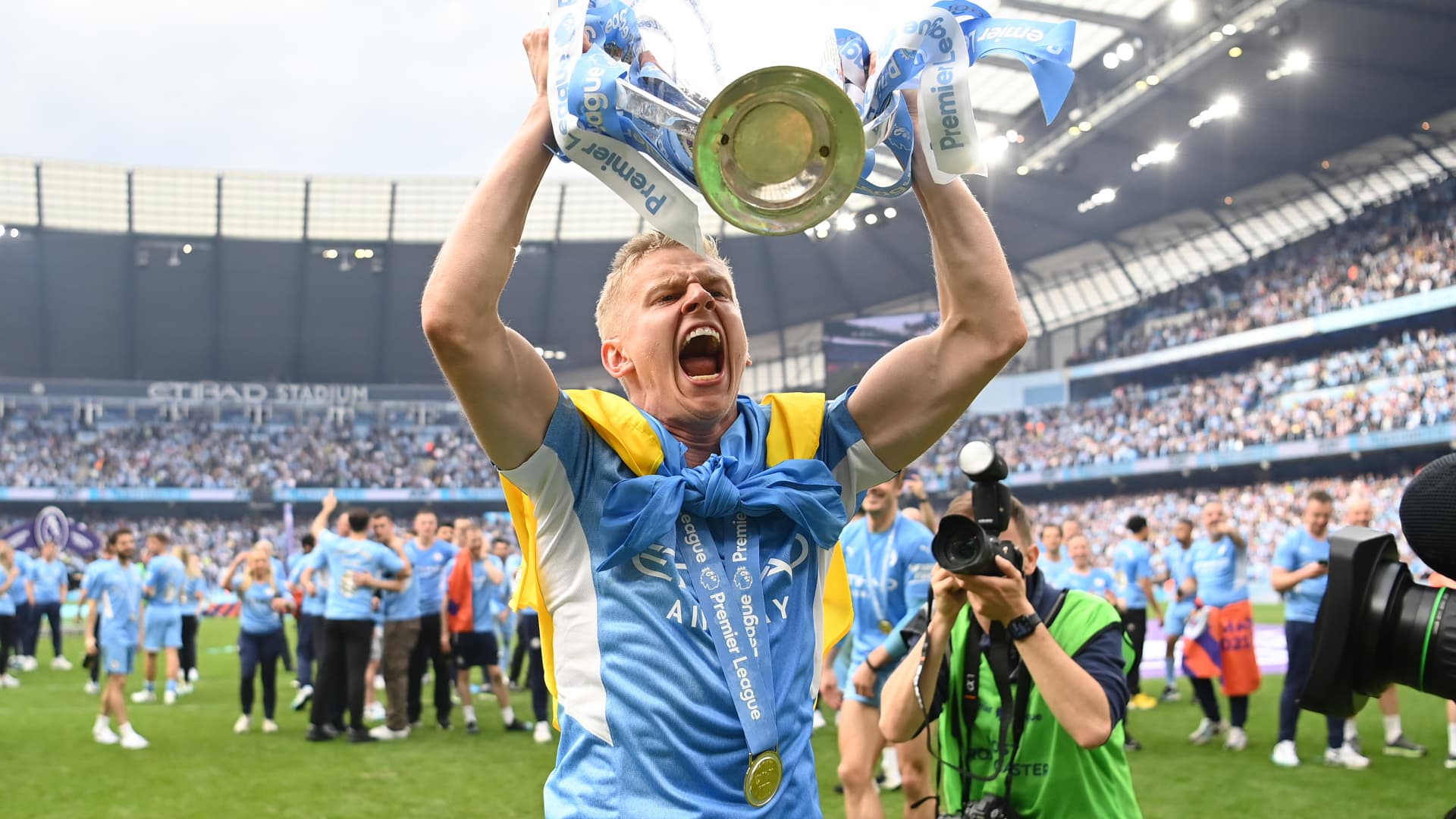 Oleksandr Zinchenko of Manchester City celebrates with the Premier League trophy and a Ukrainian flag after their side finished the season as Premier League champions during the Premier League match between Manchester City and Aston Villa at Etihad Stadium on May 22, 2022 in Manchester, England. 
