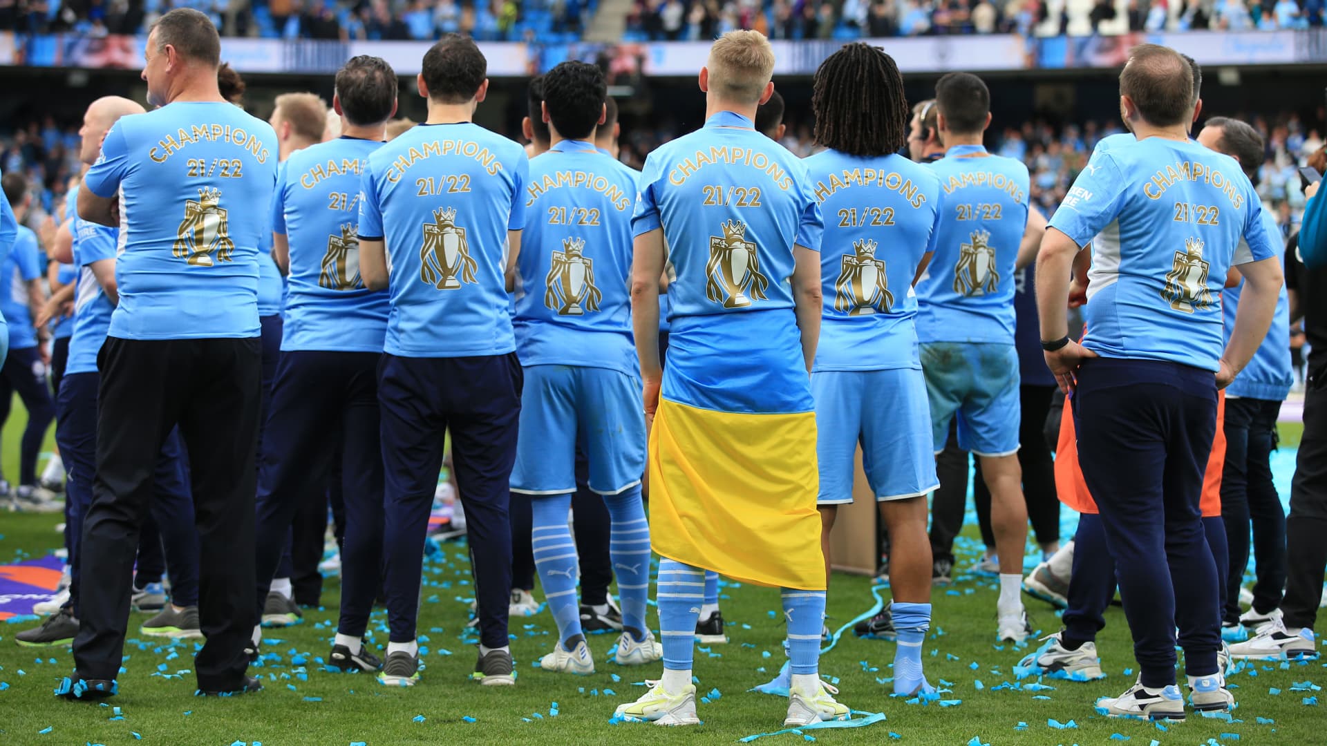 Oleksandr Zinchenko of Manchester City stands with his teammates with a Ukraine flag wrapped around his waist after the Premier League match between Manchester City and Aston Villa at Etihad Stadium on May 22, 2022 in Manchester, United Kingdom. 
