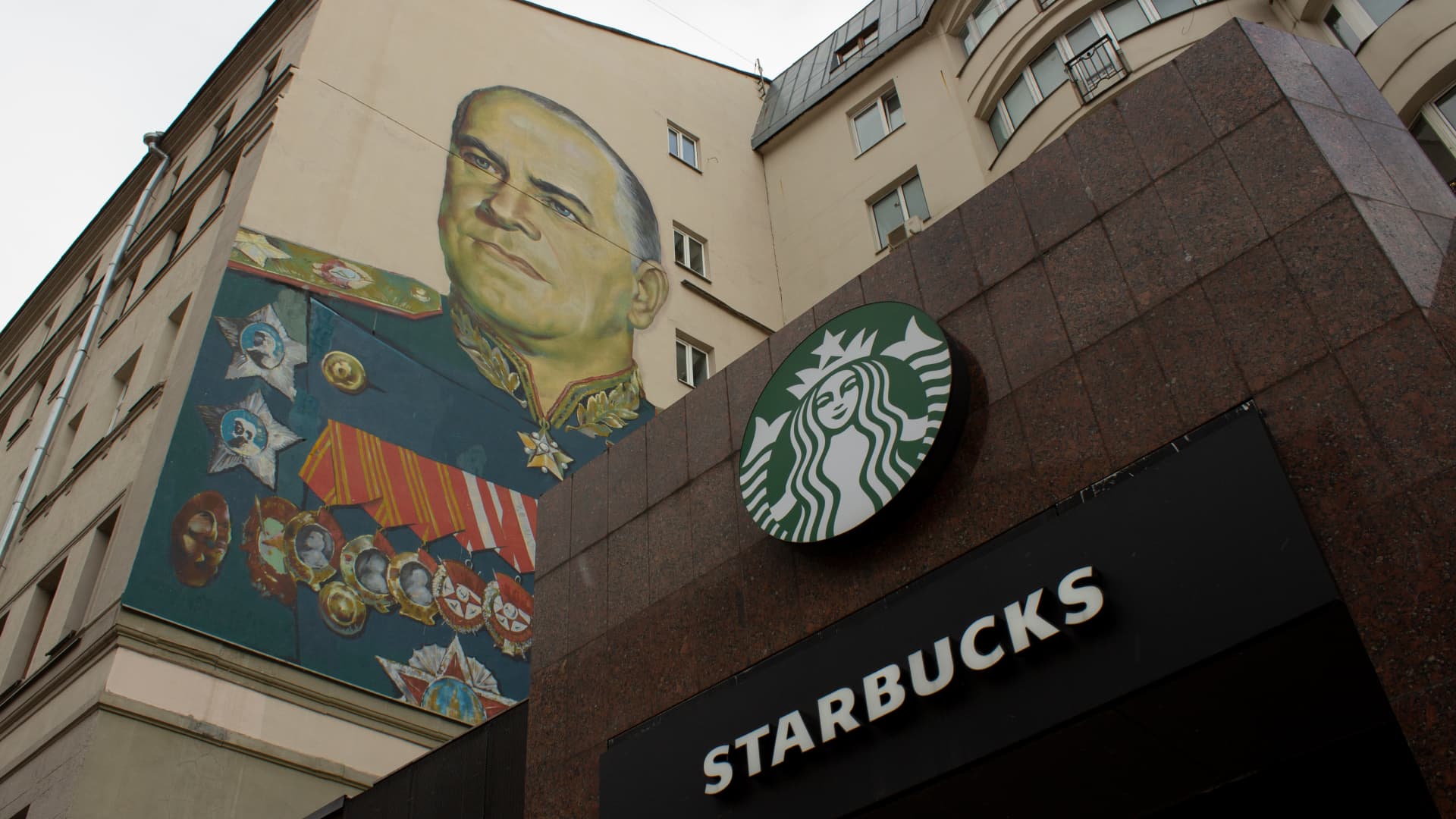 MOSCOW, RUSSIA - 2022/03/27: A Starbucks sign is seen alongside the mural of Georgy Zhukov, a Soviet general and Marshal of the Soviet Union who oversaw some of the USSRâs most decisive victories over Nazi Germany during WWII. (Photo by Vlad Karkov/SOPA Images/LightRocket via Getty Images)