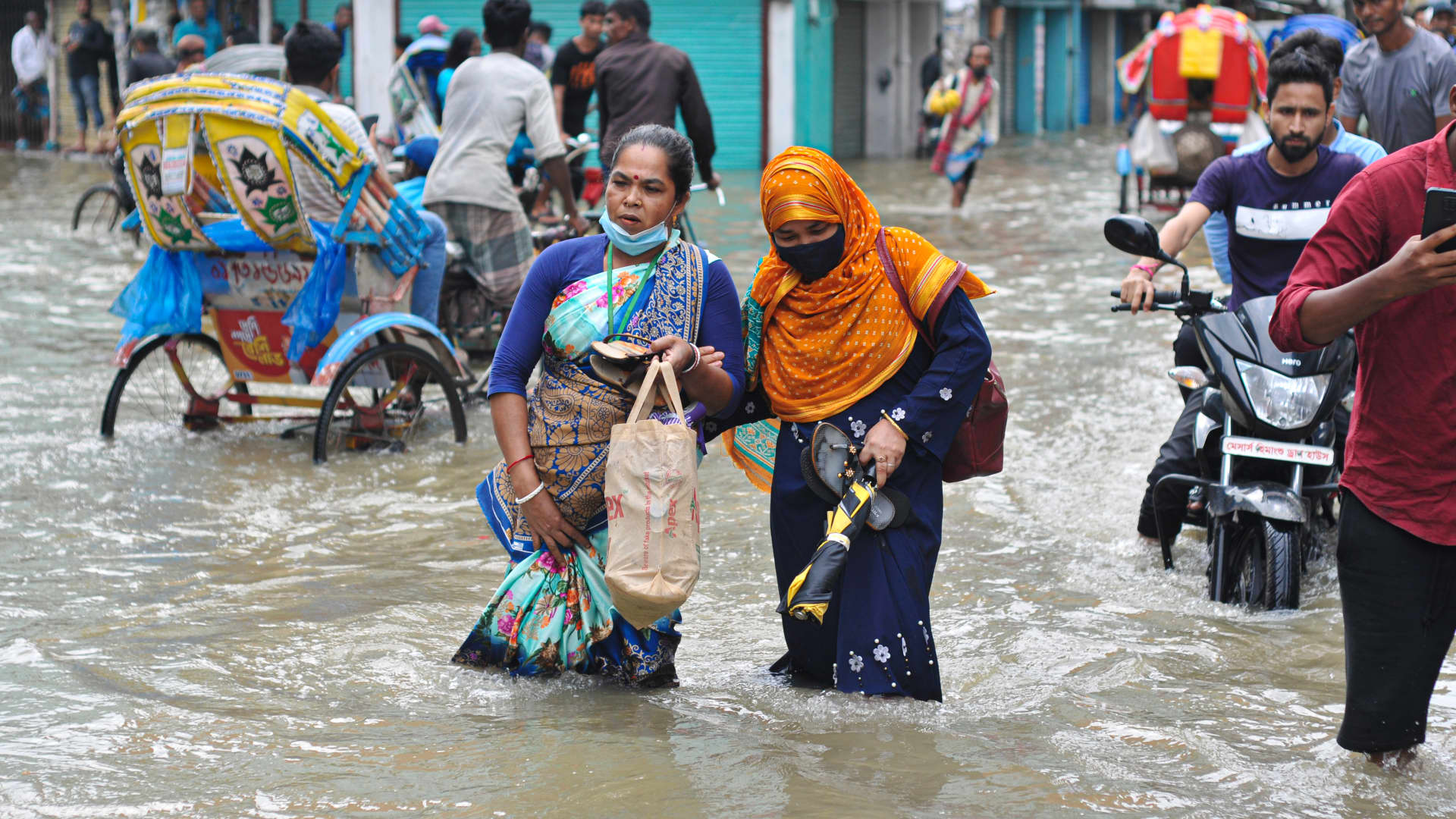 People wade through the floodwater, May 17, 2022 in Sylhet, Bangladesh. Many roads in Sylhet have been submerged due to continuous high rains for several days.