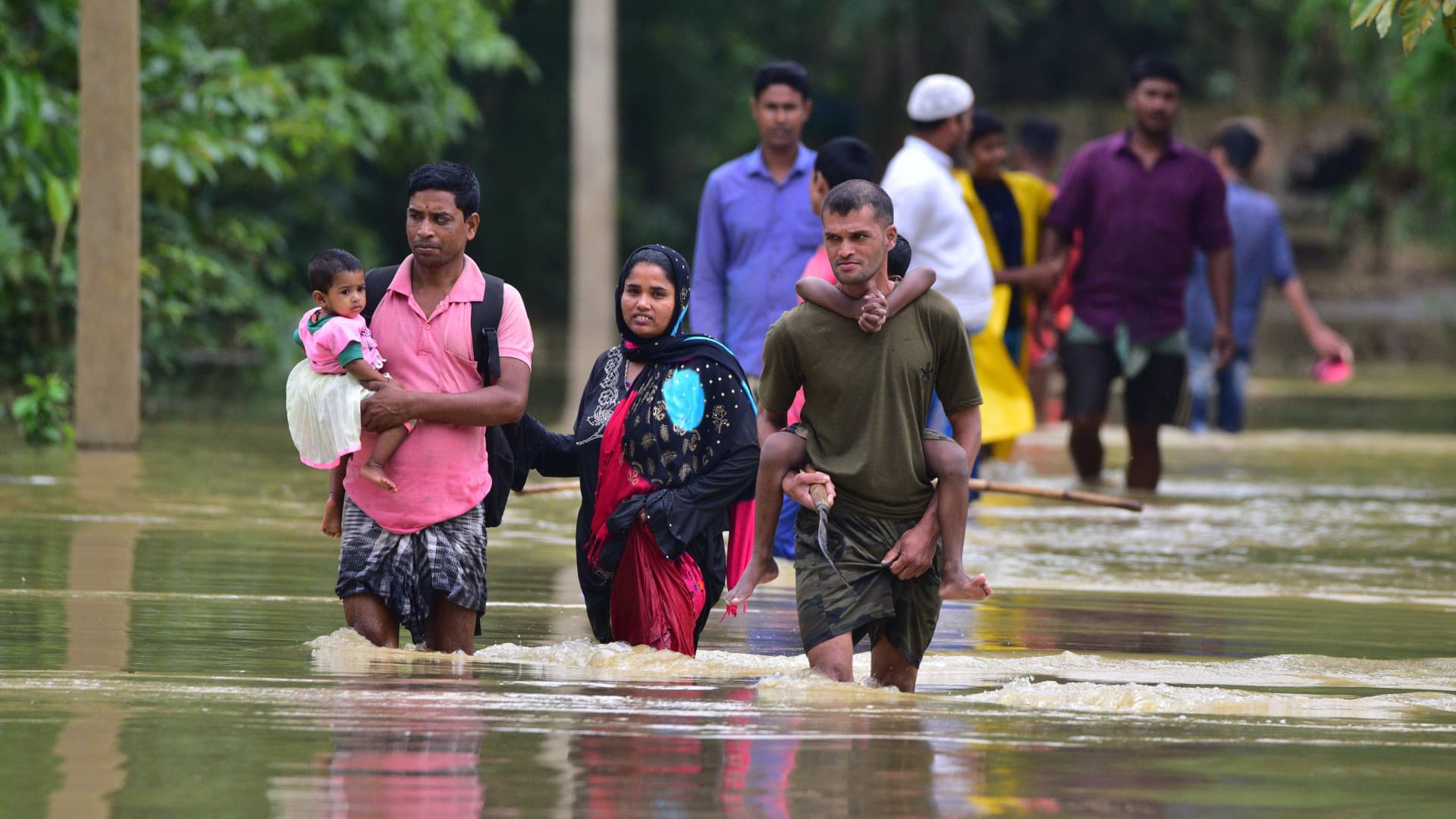 Villagers wade through a flooded area of Bakula Guri village in Nagaon district of India's northeastern state of Assam, May 15, 2022.