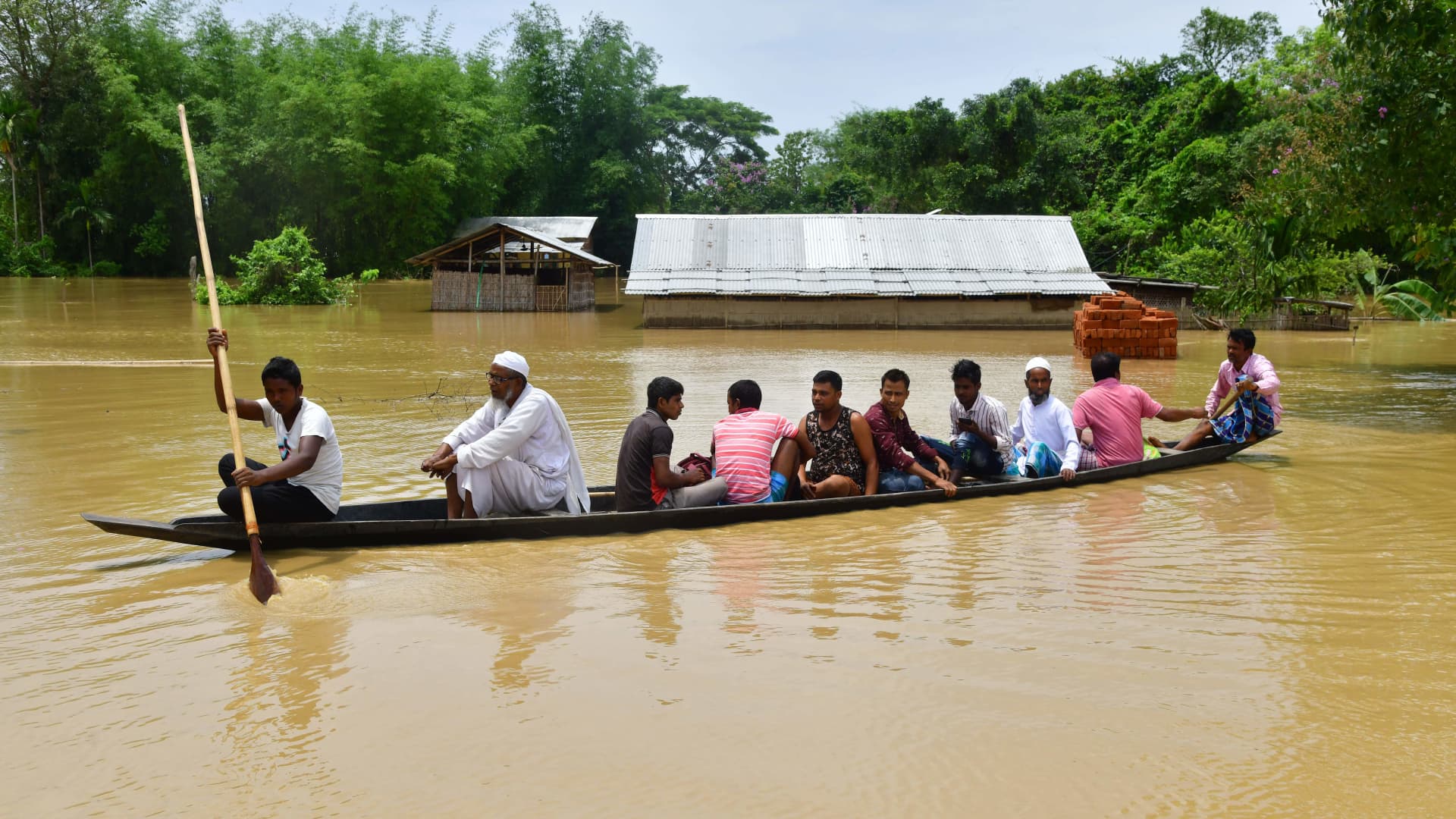 Villagers travel on a boat through a flooded area after heavy rains in Nagaon district, Assam state, on May 19, 2022.