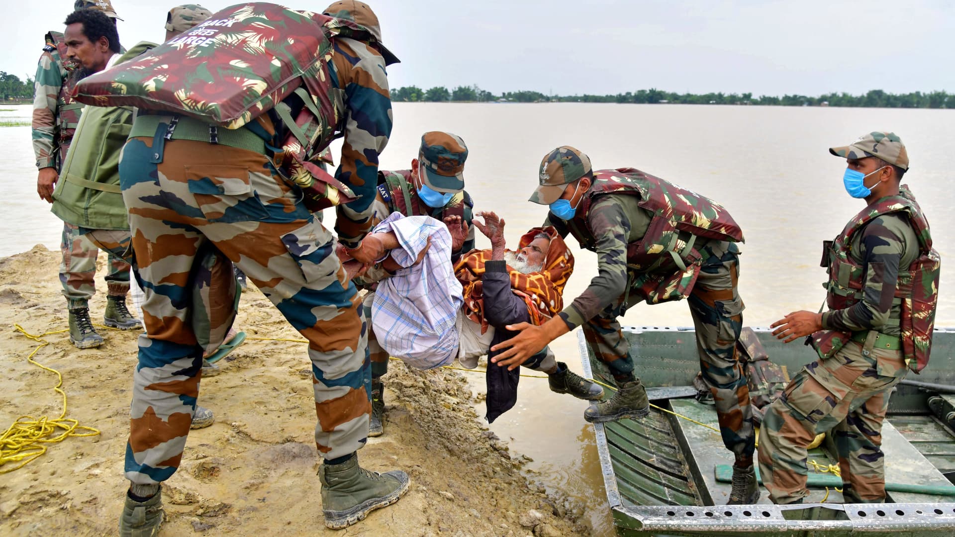 Army soldiers evacuate a flood-affected villager after heavy rains in Hojai district of India's Assam state on May 19, 2022.